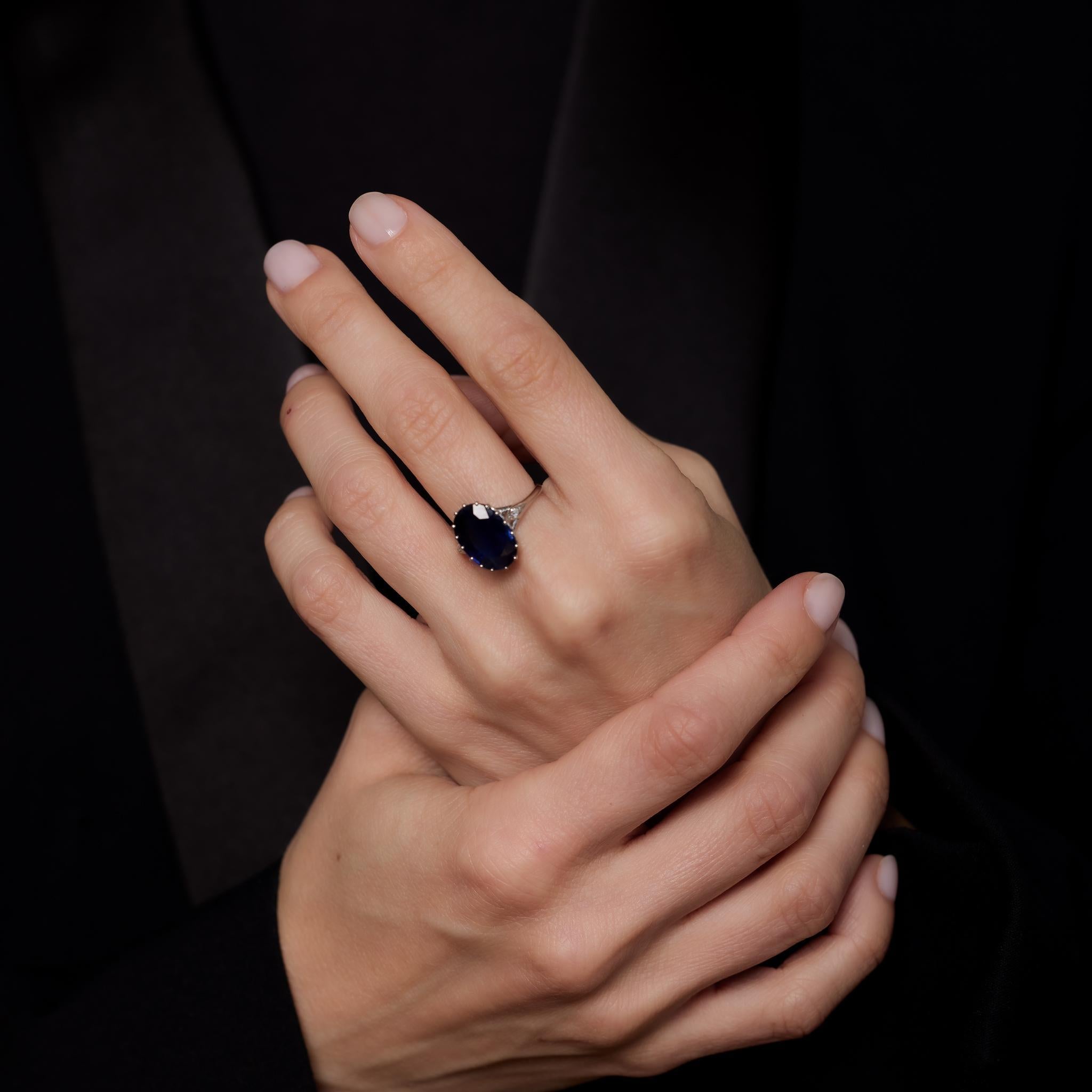 Cette bague en platine du milieu du siècle met en valeur un saphir bleu ovale de 5,75 carats certifié par la GIA et provenant de Thaïlande (chauffé), accentué par deux diamants taille unique totalisant 0,01 carat, de couleur H et de pureté SI.