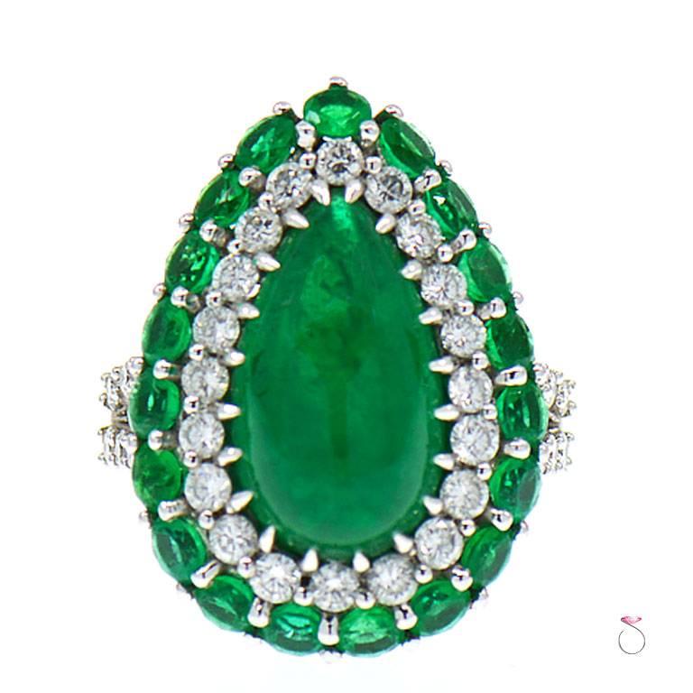 5.82ct Pear shape cabochon emerald set in a double halo diamond ring set in 18K white gold. A gorgeous design for this 5.82ct pear cabochon cut natural emerald set on a double halo of round diamonds & emeralds on a beautifully crafted 18K white gold