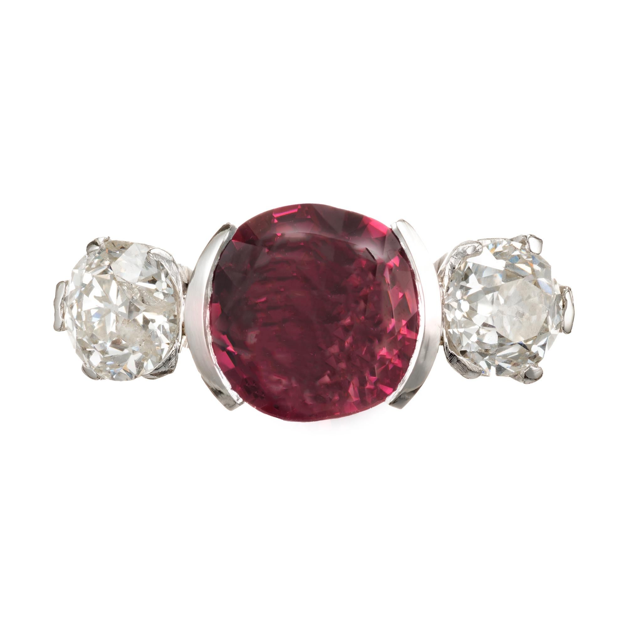1920's Spinel and diamond three-stone engagement ring. Cushion cut pink Spinel half bezel set center stone with two old mine brilliant cut side diamonds. GIA certified no heat Spinel of 3.75cts of old cut.

1 cushion purplish pink Spinel, approx.