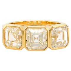 GIA Diamante talla Asscher de 6,02 quilates de peso total Anillo de tres piedras de oro amarillo de 18k
