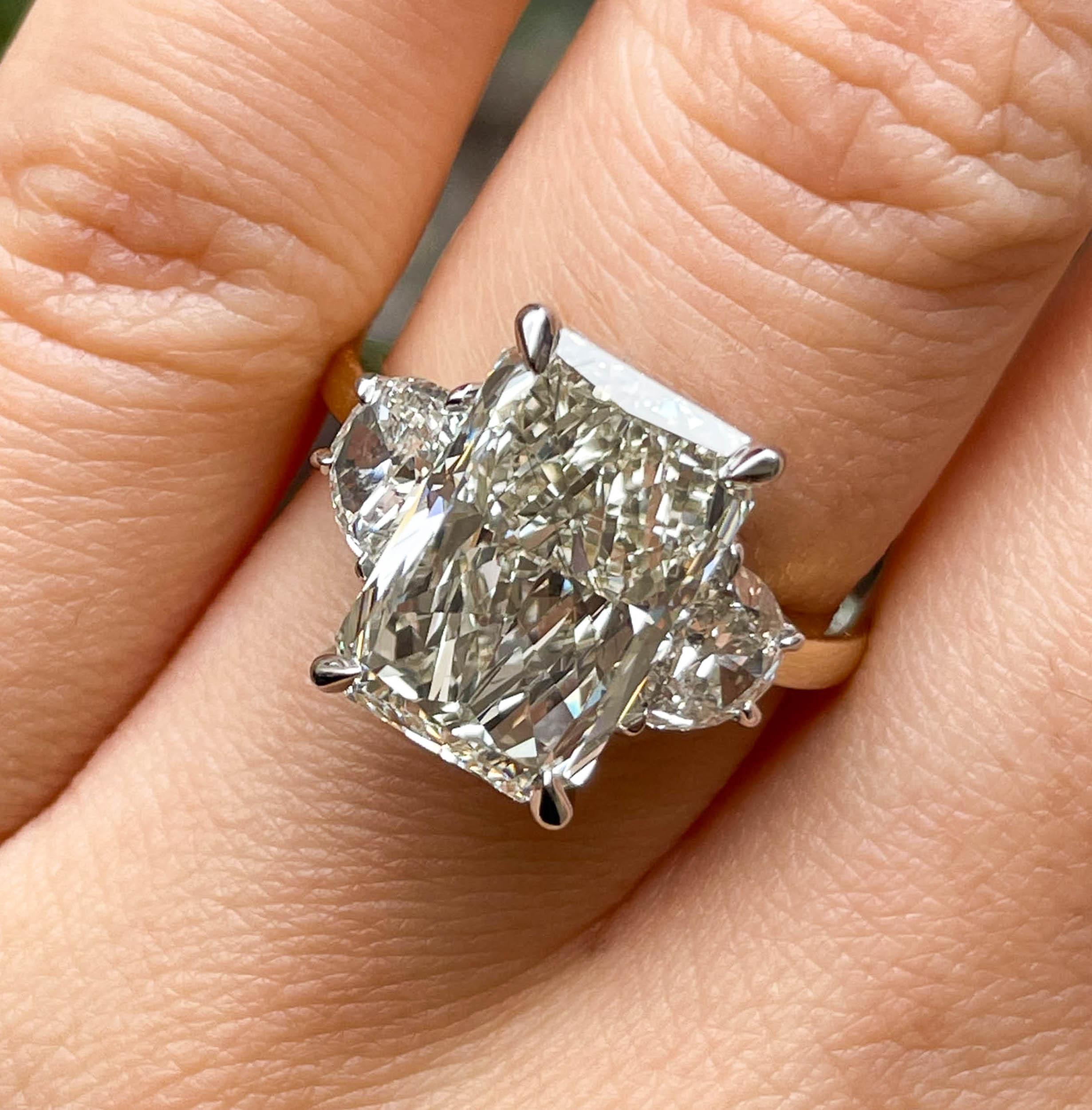 A Breathtaking Estate HANDMADE Platinum/18k Yellow Gold (stamped) Radiant Diamond Three-Stone Engagement ring contains GIA certified 5.21ct Radiant cut center diamond in N color and VS1 clarity; with measurements of 12.55x8.36x5.40mm. GIA report #