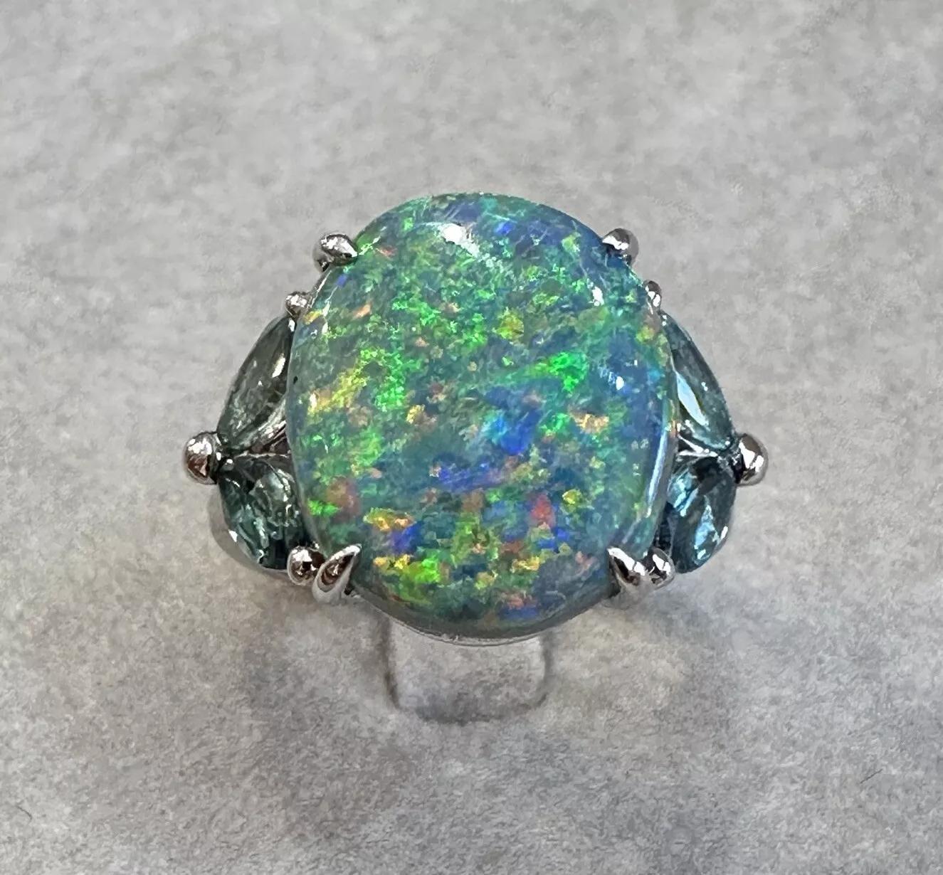 GIA Certified 6.55 carat Black Opal and Aquamarine Ring in Platinum 

Black Opal and Diamond Ring features a GIA certified Black Opal weighing 6.55 carats with Blue, Green, Yellow, and Orange play of color accented with four Marquise shaped