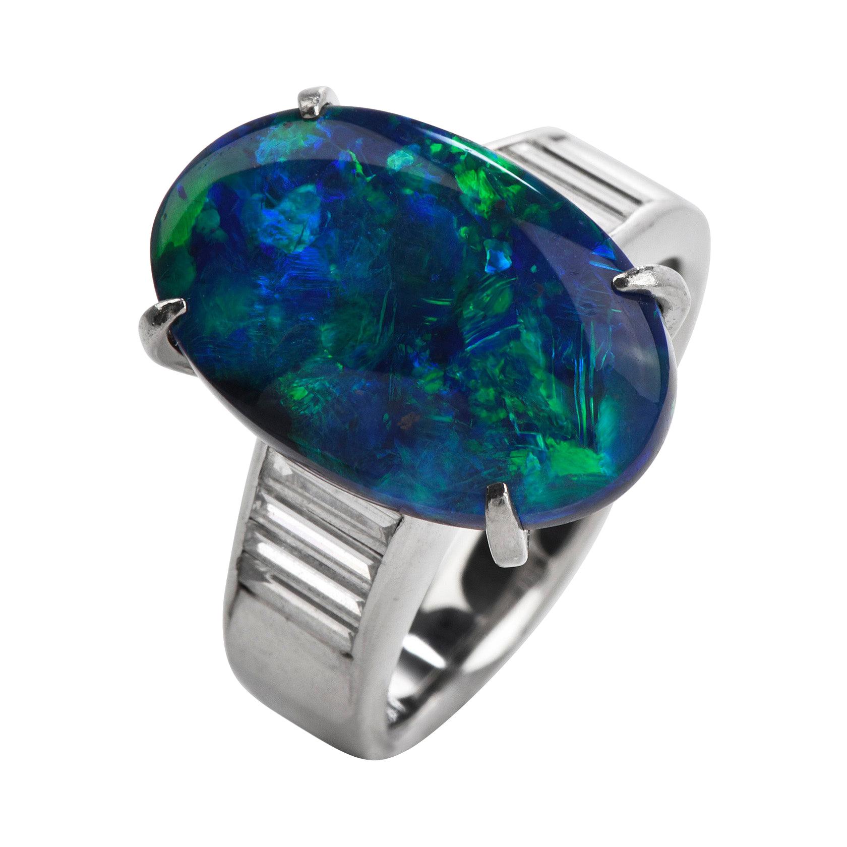 This GIA Natural Black Opal and Diamond Cocktail Ring  with a total weight of 11.18 grams. Centered  with natural genuine Black opal Expertly mounted in solid platinum weighing approx. 7.00 carats, accentuated by 8 baguette-cut Genuine Diamonds