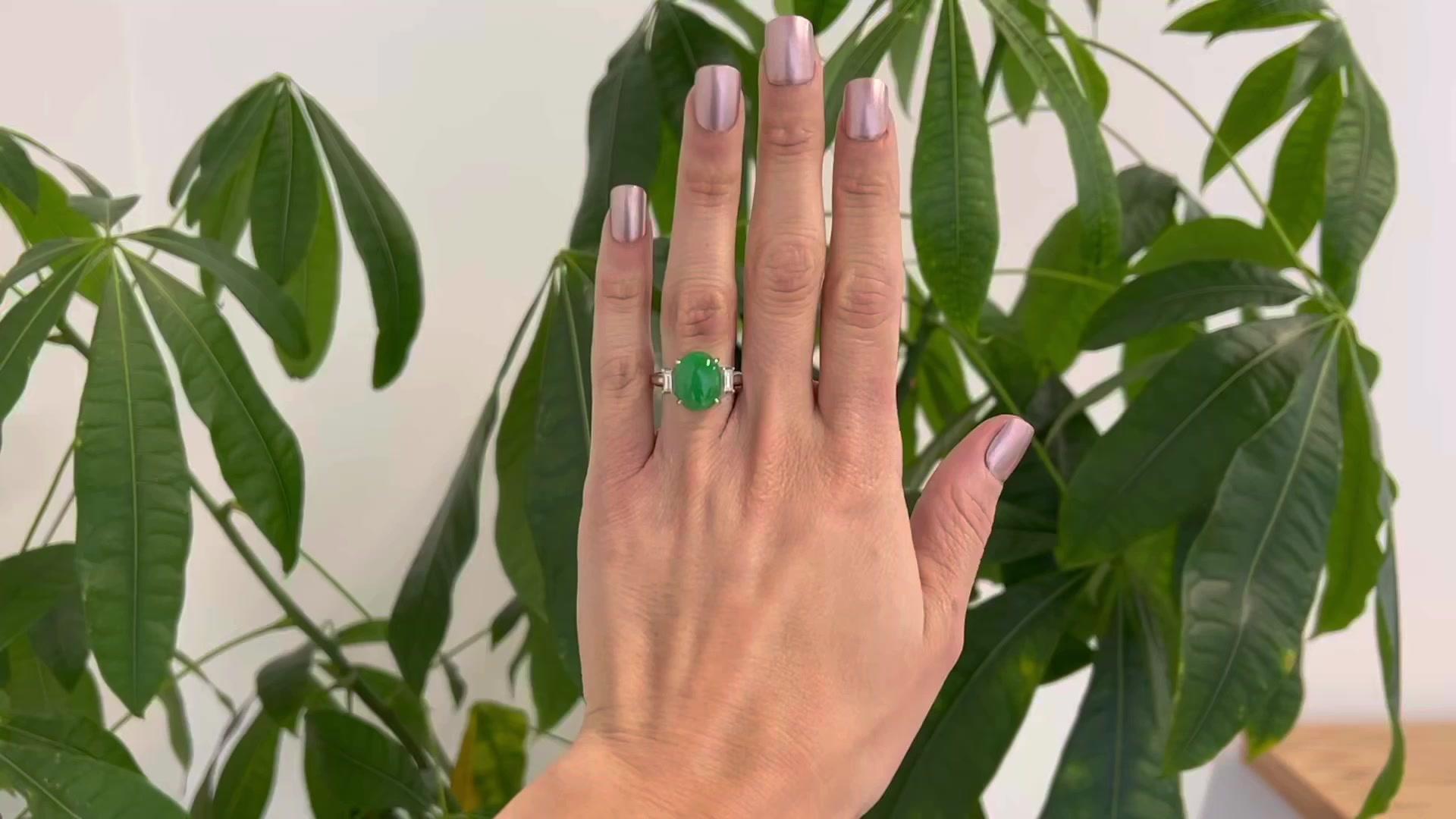 One GIA 7.56 Carat Untreated Jade Diamond Platinum Ring. Featuring one GIA natural jade cabochon weighing 7.56 carats, accompanied with certificate #5221670601 stating the stone has not been treated. Accented by two baguette cut diamonds with a