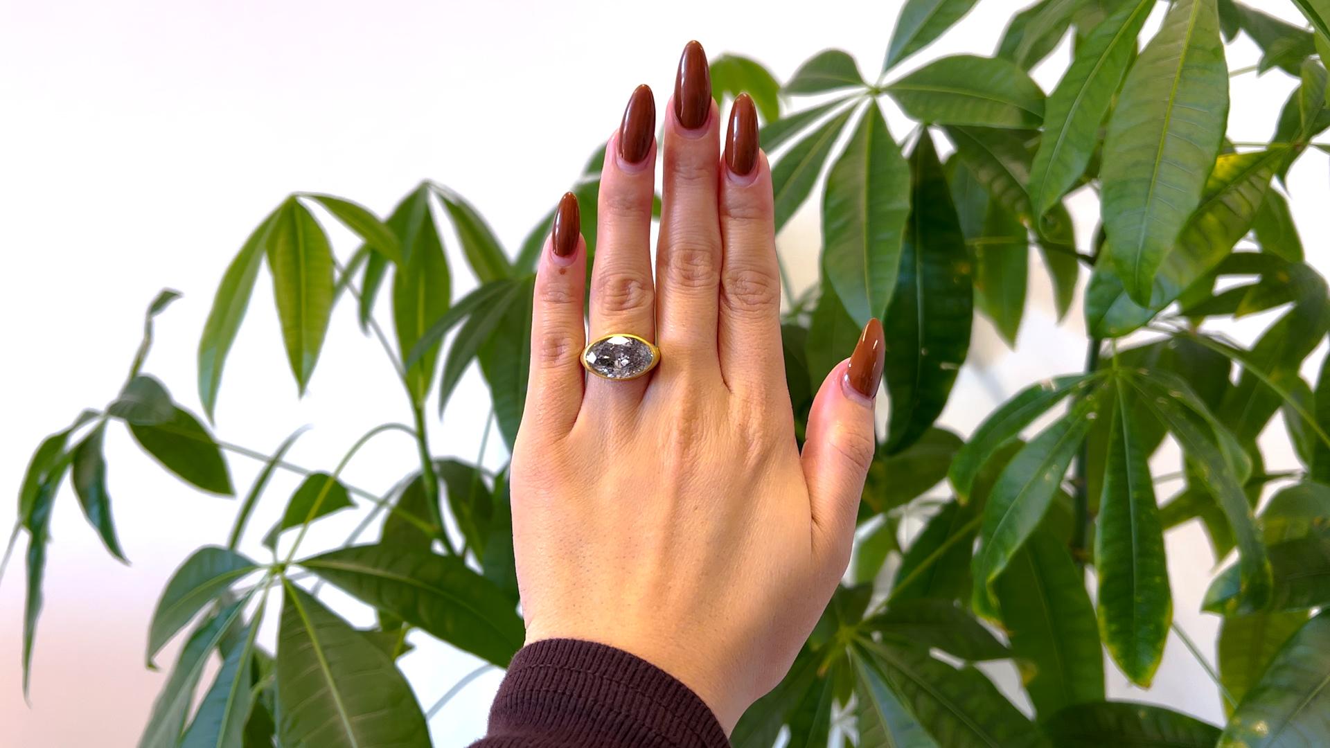 One GIA 7.66 Carat Salt & Pepper Diamond 18k Yellow Gold Bezel Set Ring. Featuring one GIA oval cut salt and pepper diamond of 7.66 carats, accompanied with GIA #2231064552 stating the diamond is a faint gray color, I3 clarity. Crafted in 18 karat