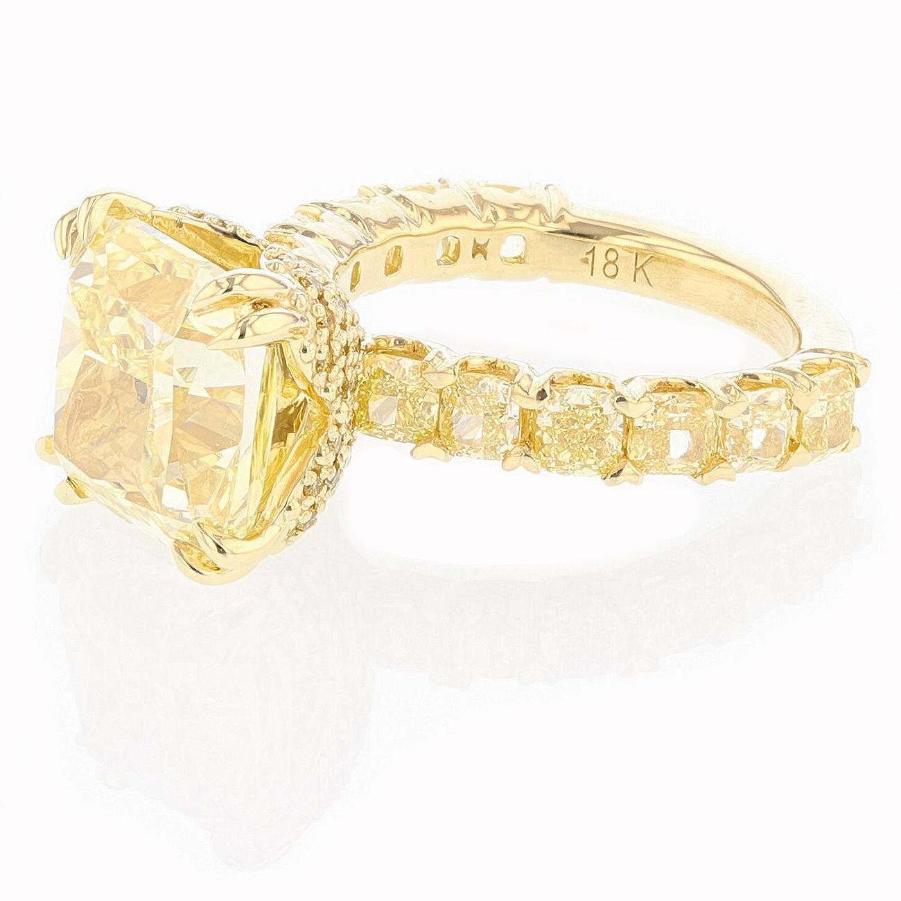 This ring is made in 18K yellow gold and features a 8.03ct Fancy Yellow Cushion cut Diamond clarity grade VVS2 with GIA certificate # 6193658610. The ring features 12 cushion cut diamonds weighing 2.63 ct Color Grade (Fancy Yellow) Clarity Grade