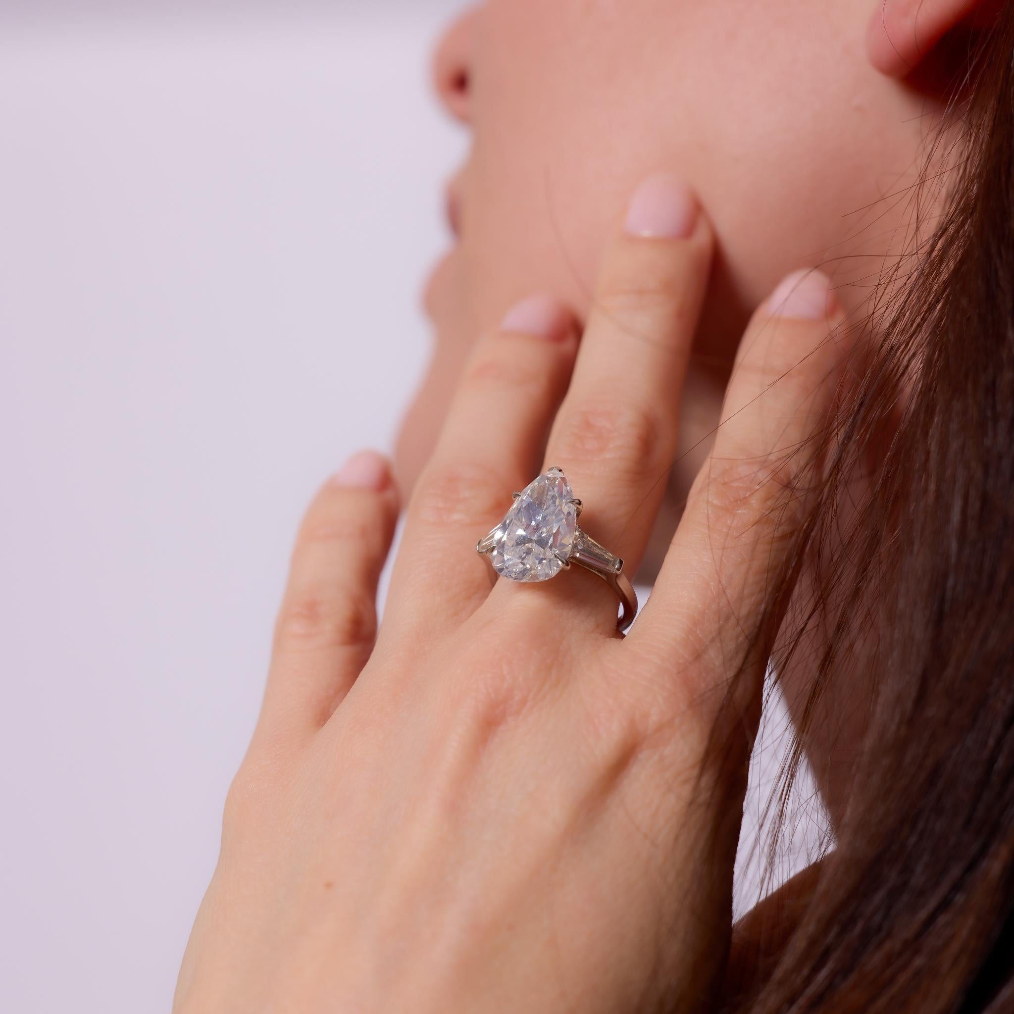 Crafted in the 1960s, this Mid Century platinum engagement ring showcases a GIA-certified 8.50-carat pear cut diamond, graded J color and SI1 clarity. The impressive center stone is flanked by two tapered baguette cut diamonds totaling approximately