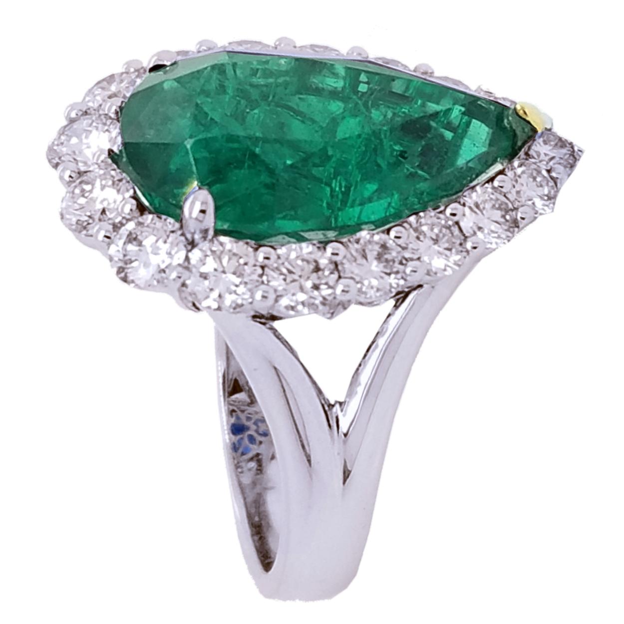 A beautiful color GIA Certified 8.90 Ct Pear shaped Emerald  set in the center of an 18K split shank diamond Engagement Ring with a Halo to create great contrast. 

Details:
Center Stone: GIA certified 8.90 carat Pear shaped Emerald
Center Stone