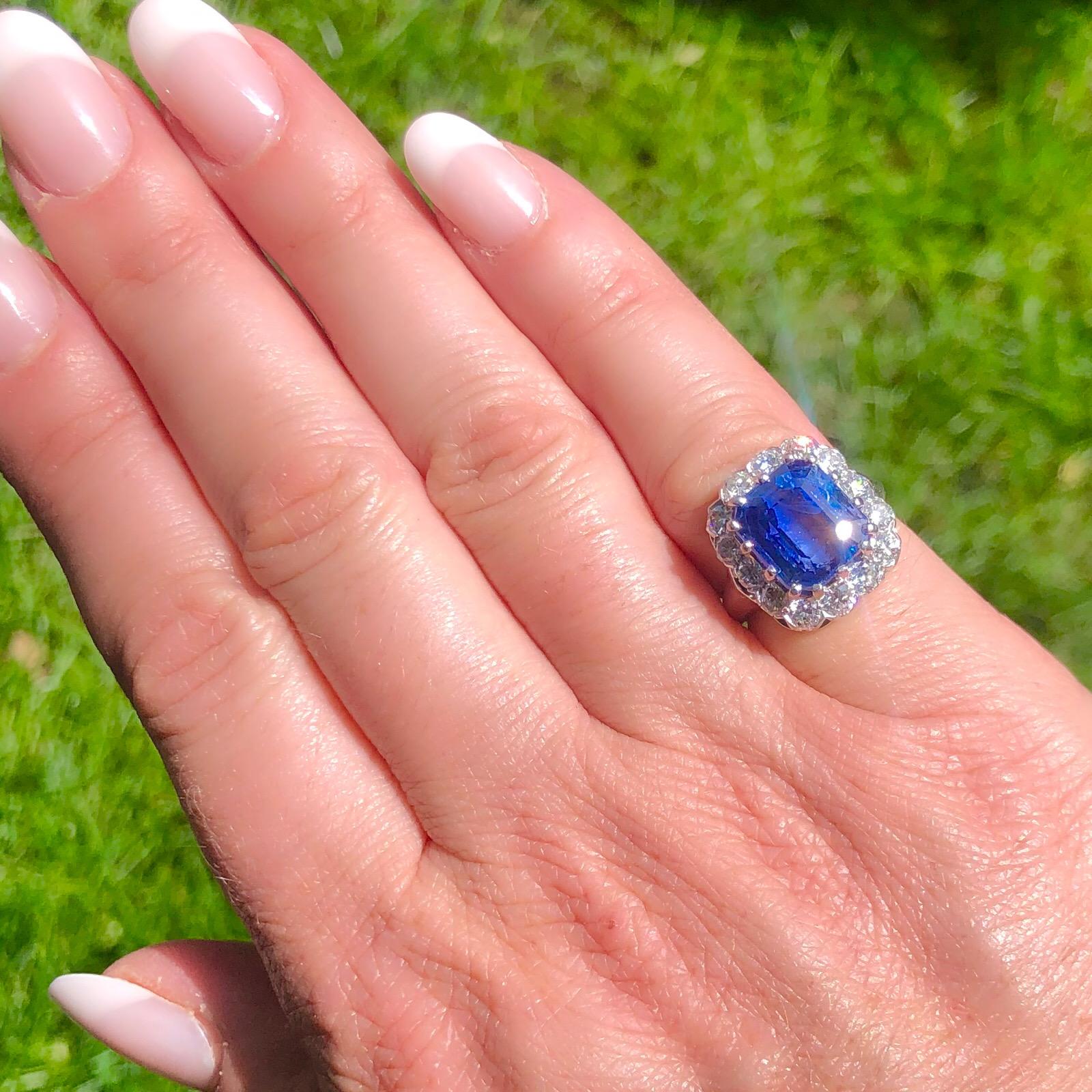 When only the finest will do. This lovely rectangular step-cut unheated Ceylon blue sapphire weighing 9.00 carats, is framed with a halo of 14 transitional round brilliant-cut diamonds, totaling approximately 1.40 carats. Set in 14k white gold, the