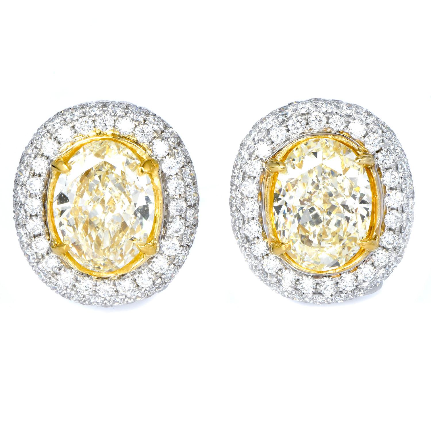 Vous vous sentirez glamour et royale avec ces diamants naturels jaunes de forme ovale  Boucles d'oreilles Halo.  Les deux diamants jaunes naturels ovales centraux pèsent 3,10 carats, de couleur U à V, de pureté VS1 et 3,59 carats de couleur U-V, de