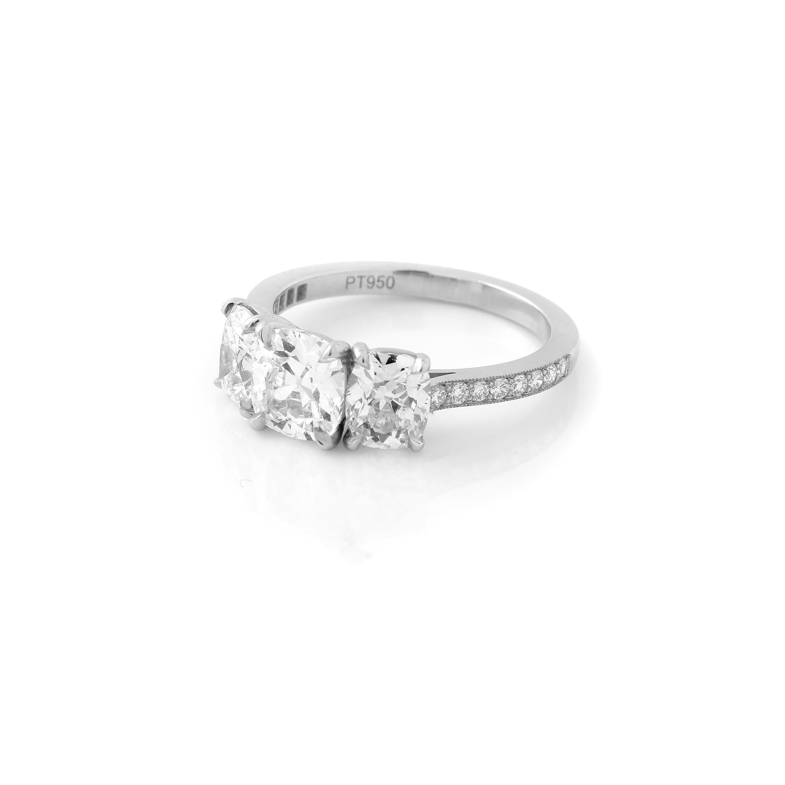 This classic three-stone ring features a GIA certified 1.06 carat D VVS1 antique-cut cushion center and a pair of D/E VS antique-cut cushion side stones, weighing 1.45 carats. The three cushion diamonds are set in a timeless pavé platinum mounting,