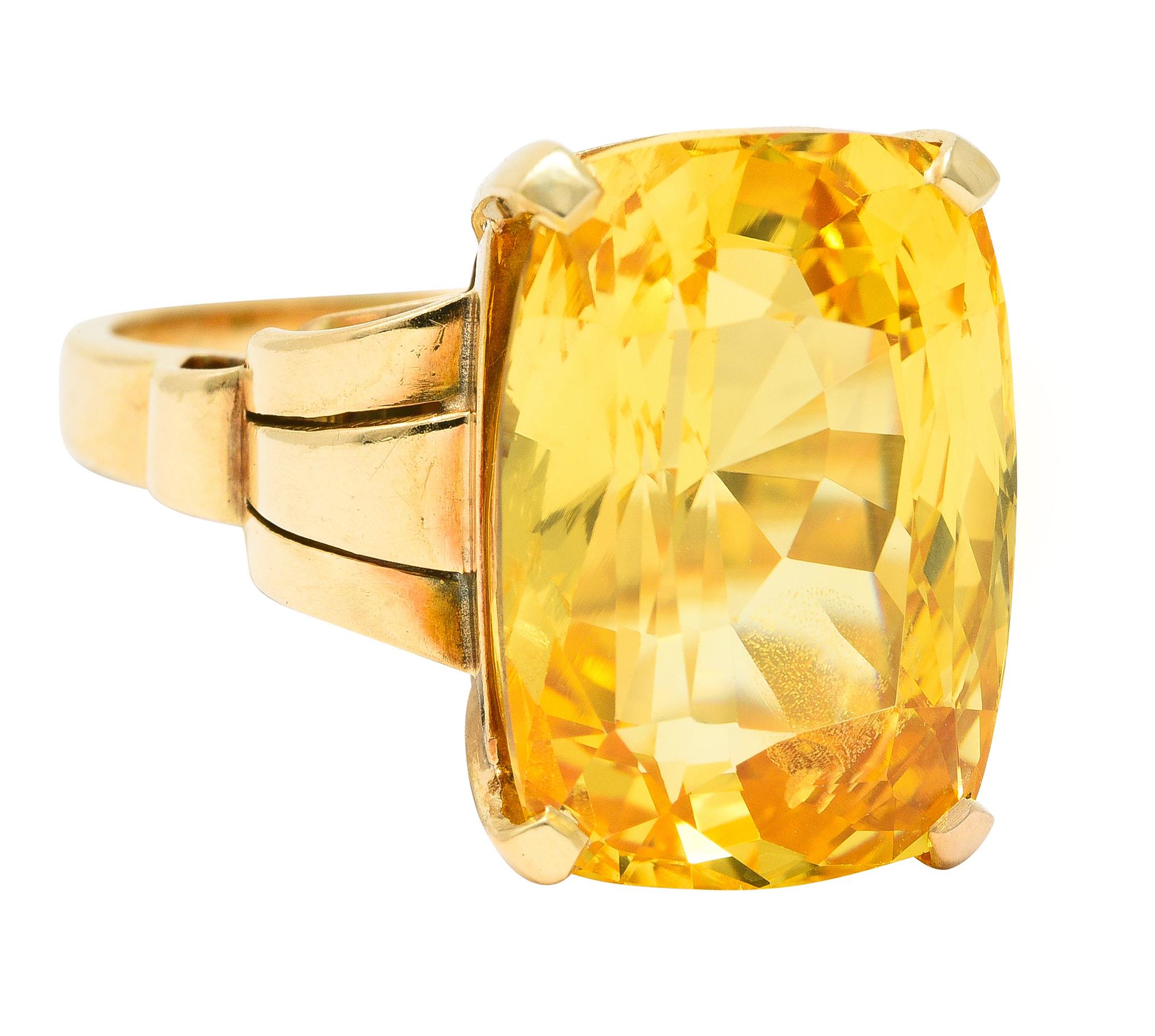 Centering a cushion cut sapphire weighing 17.33 carats total - transparent medium yellow in color. Natural Ceylon in origin with no indications of heat treatment - prong set in basket. Flanked by fanning tri-split cathedral shoulders. Completed by