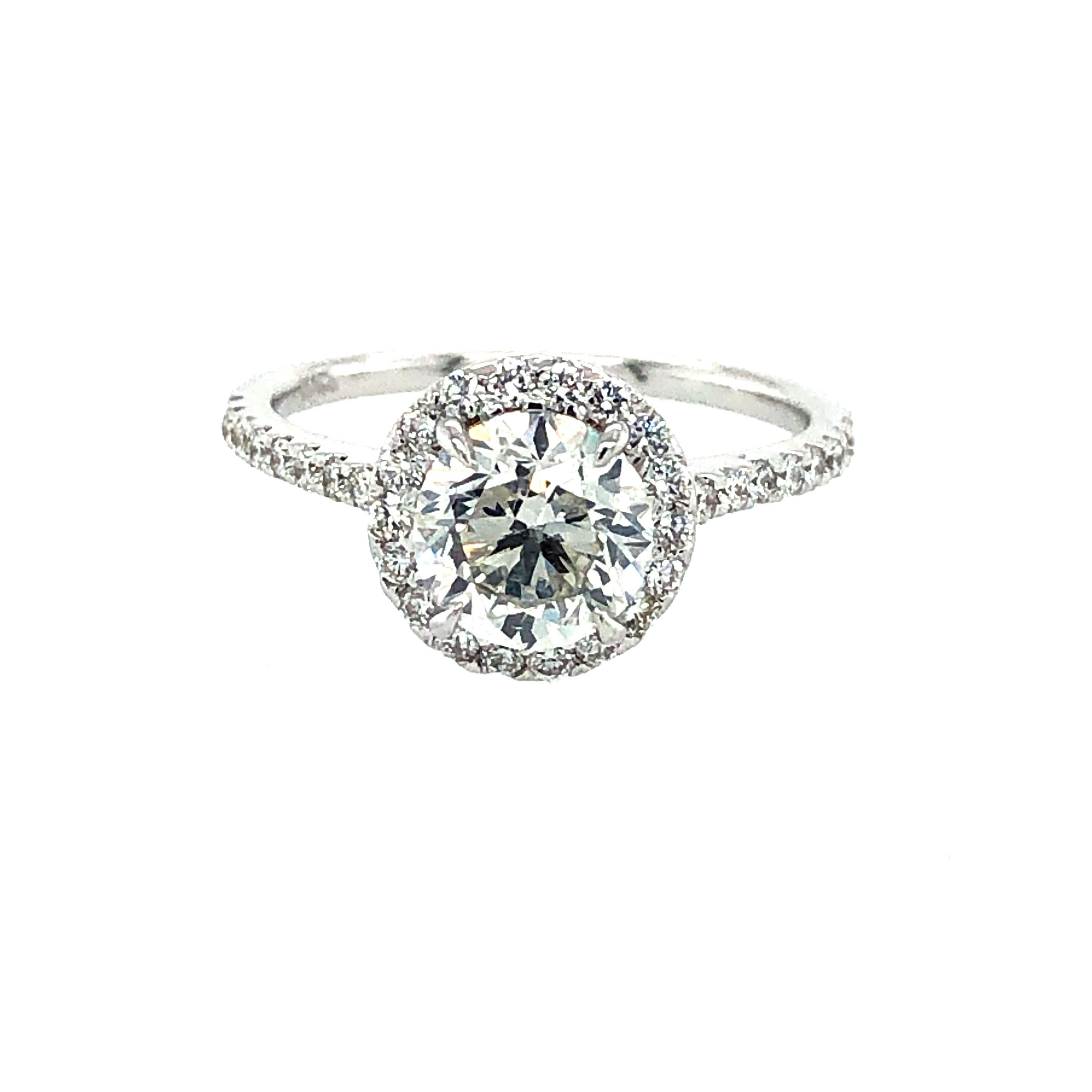 Offered here is a beautiful GIA certified 1.50 carat round brilliant cut diamond set in a classic halo diamond 18k white gold ring. The center diamond comes with a GIA cert.# 5201877158 stating 
Shape: round brilliant 
Measurements: 7.01-7.10 x 4.59