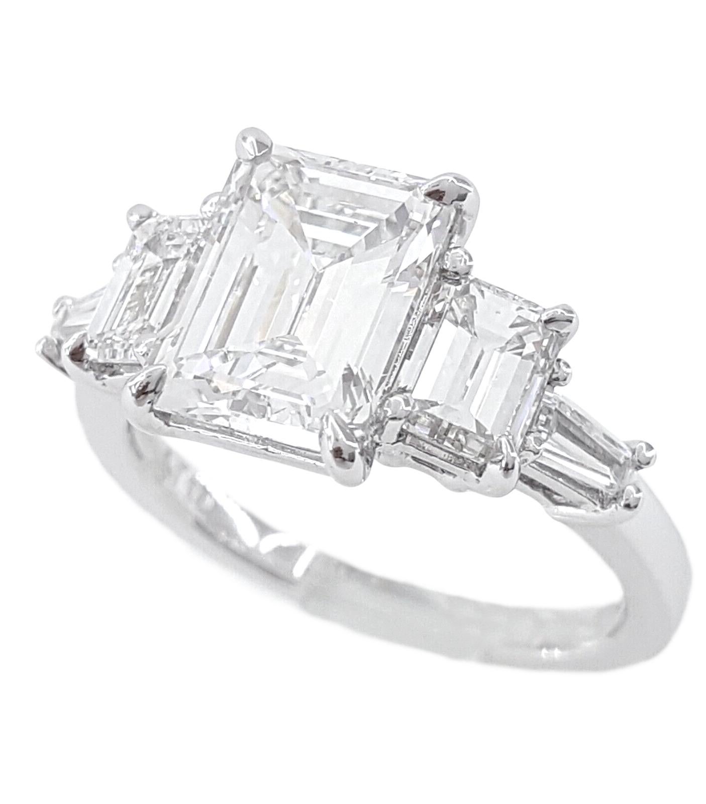 This ring is a refined work of art featuring a 4.00-carat emerald-cut main diamond certified by the GIA as F per color and VS per clarity, set in an 18K white gold band.
The three-stone design imparts a timeless and elegant touch to this