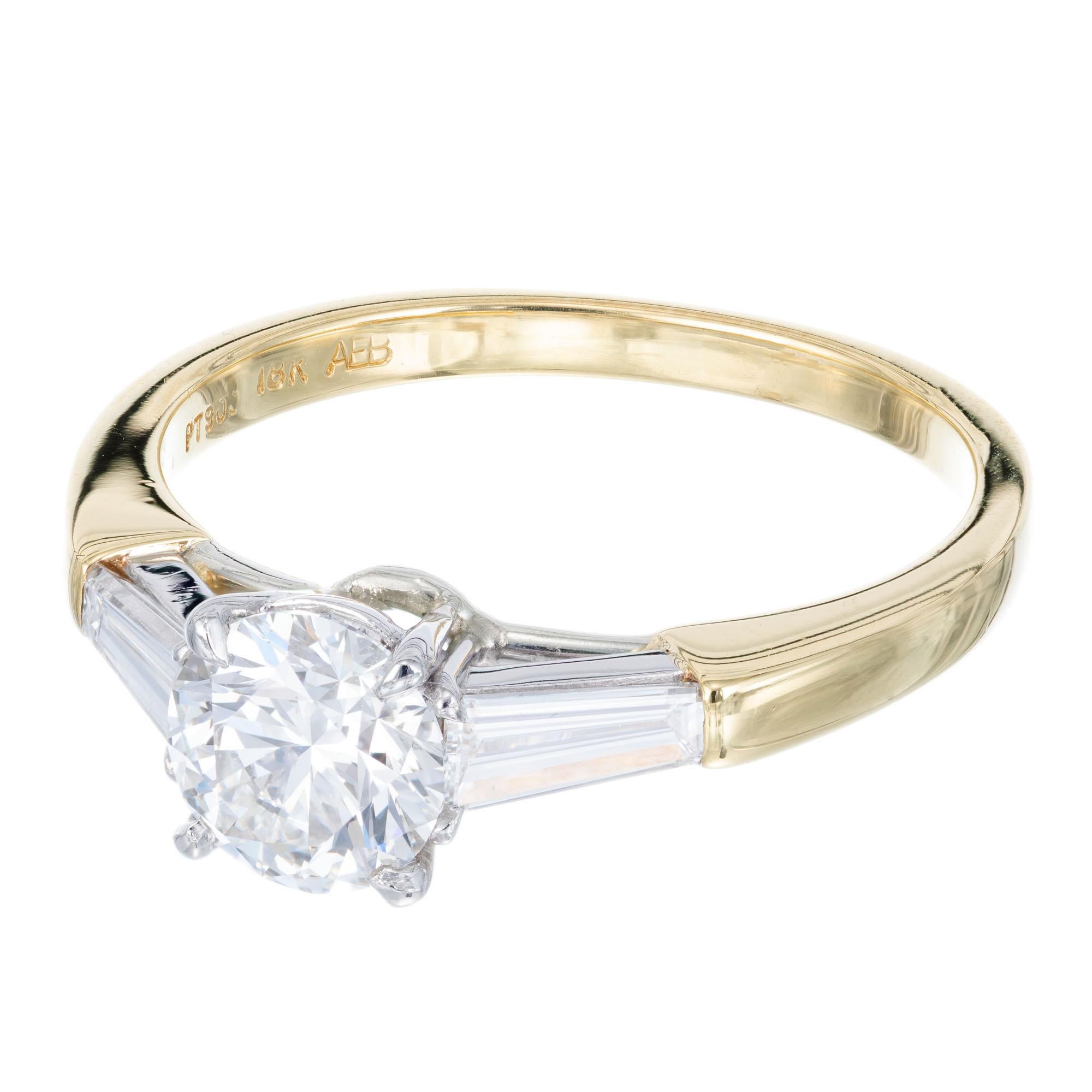 Diamond engagement ring. Platinum and 18k yellow gold three-stone setting with a GIA certified round center diamond and two tapered baguette side diamonds. 

Ideal cut diamond, approx. total weight .90cts, and 6.18 x 6.24 x 3.85 mm, F, VVS1, Depth: