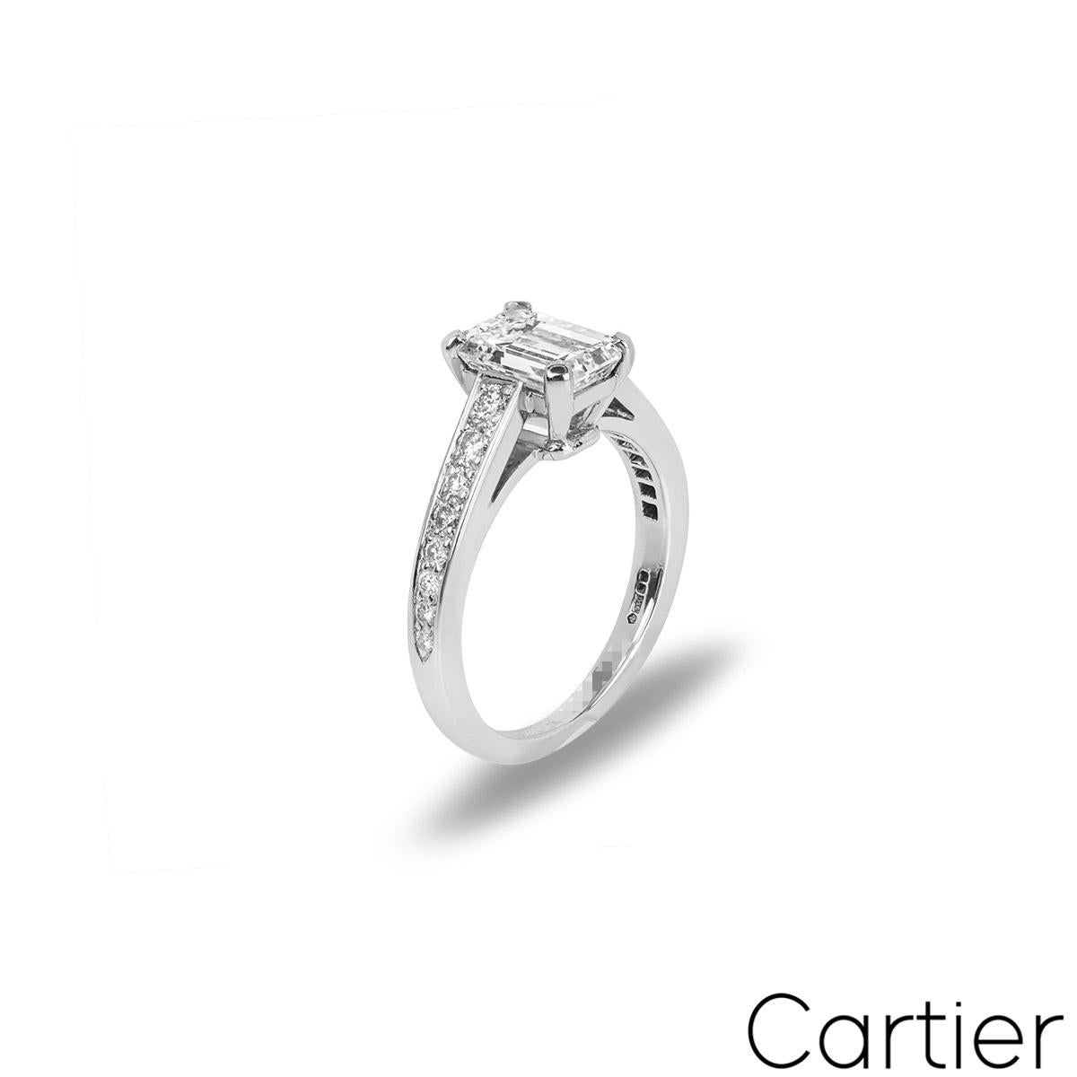 A breathtaking platinum diamond ring by Cartier from the Solitaire 1895 collection. The ring features an emerald cut diamond set to the centre weighing 1.53ct, E colour and VS1 clarity. The engagement ring tapers down from 3mm to 2mm and is pave set