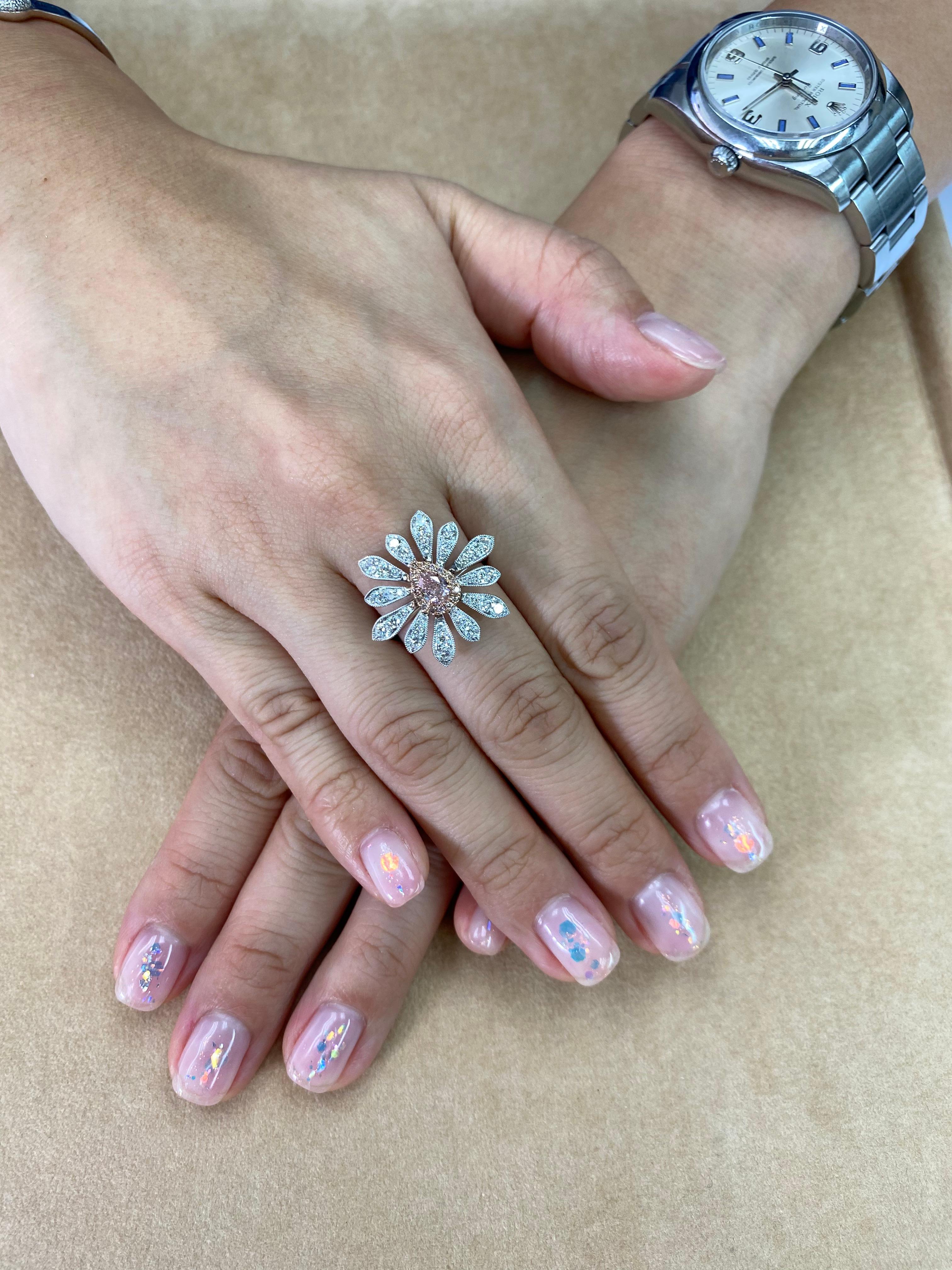 Here is a nice fancy orange pink colored diamond flower cocktail ring. Two of the rare colors combined (orange and pink) The fancy orangy pink diamond is certified by GIA to be natural and untreated. The nice pear shaped fancy orangy pink center