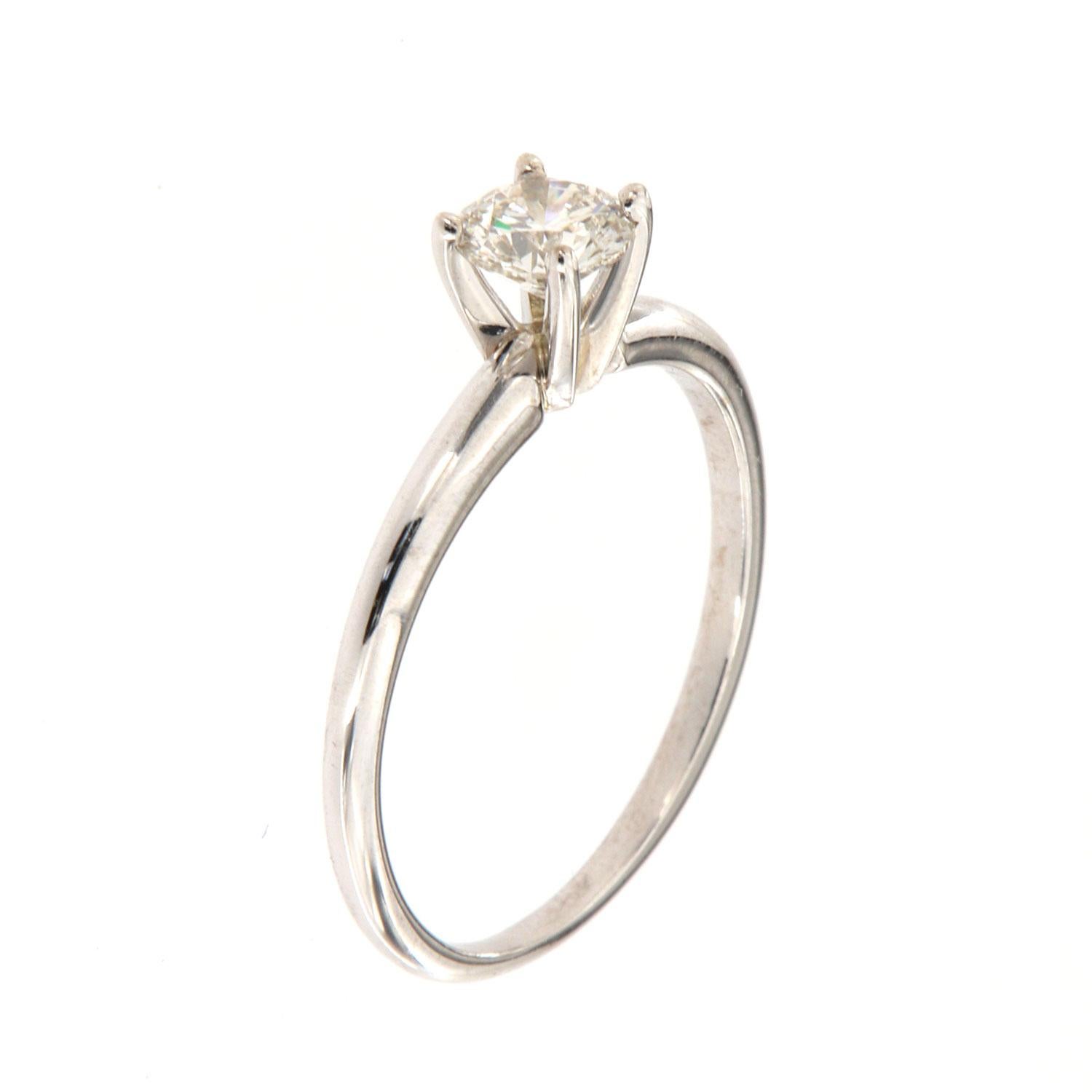 This classic solitaire 14k white gold ring features a 0.50 Carat round brilliant diamond four (4) prongs set on a 2 mm wide band. It's 100% eye clean, face-up white with an excellent luster. The Center diamond is GIA certified.  Color: J Clarity: