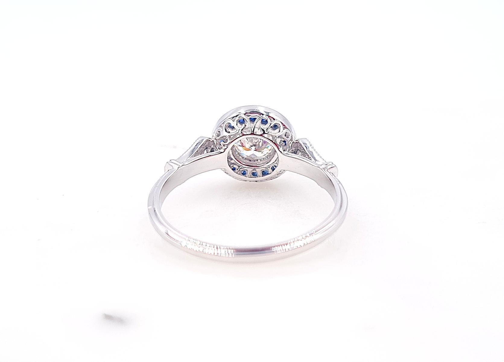 Art Deco style ring with a 0.52ct old transitional cut diamond surrounded by a royal blue natural sapphires halo. 
The main stone is perfect white and totally clean GIA certified Diamond, being graded D in color and VS2 in clarity.

The art deco