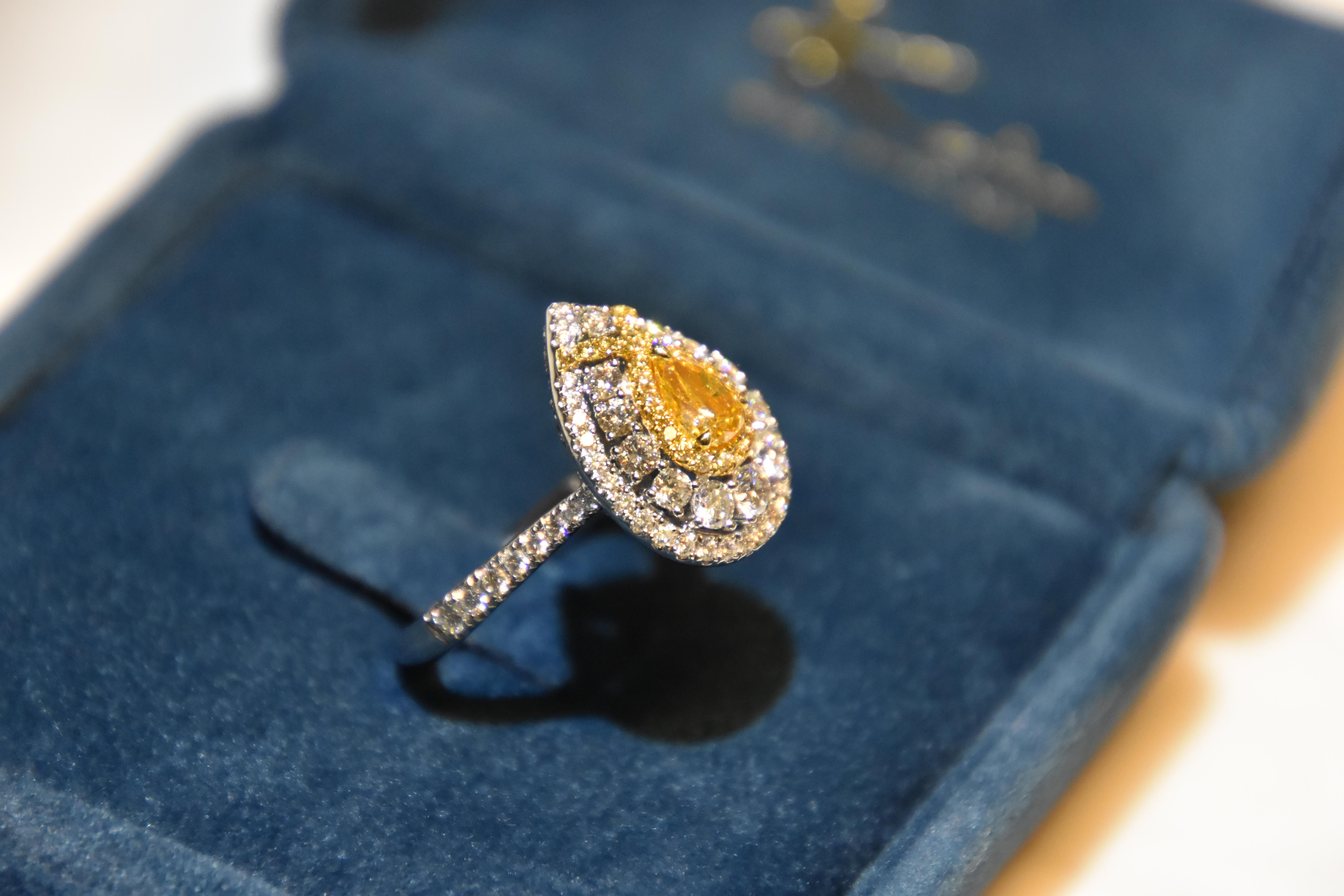 Featuring a 0.52 carat pear shape Fancy intense yellow orange diamond, finished in white gold. 

Orange diamond is one of the beautiful and unusual color diamond. Orange diamond always come with second color such as yellow/ pink and brown. 

Orange