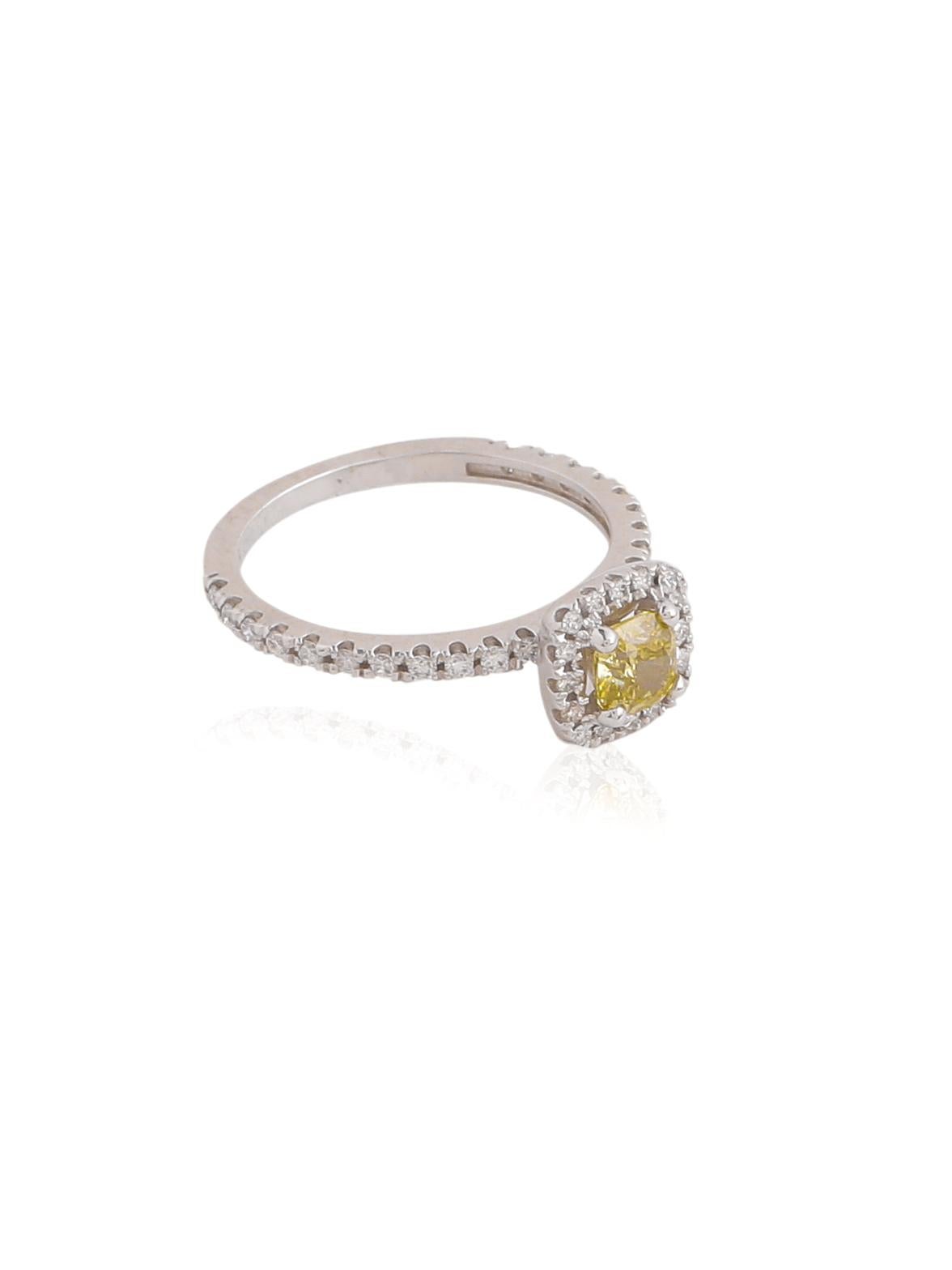 A chic and classic engagement ring with a beautiful cushion shape GIA certified diamond in the centre with a halo of smaller diamonds around it. The centre stone is a special Yellowish colour and is a pretty looking stone. 
The color on the