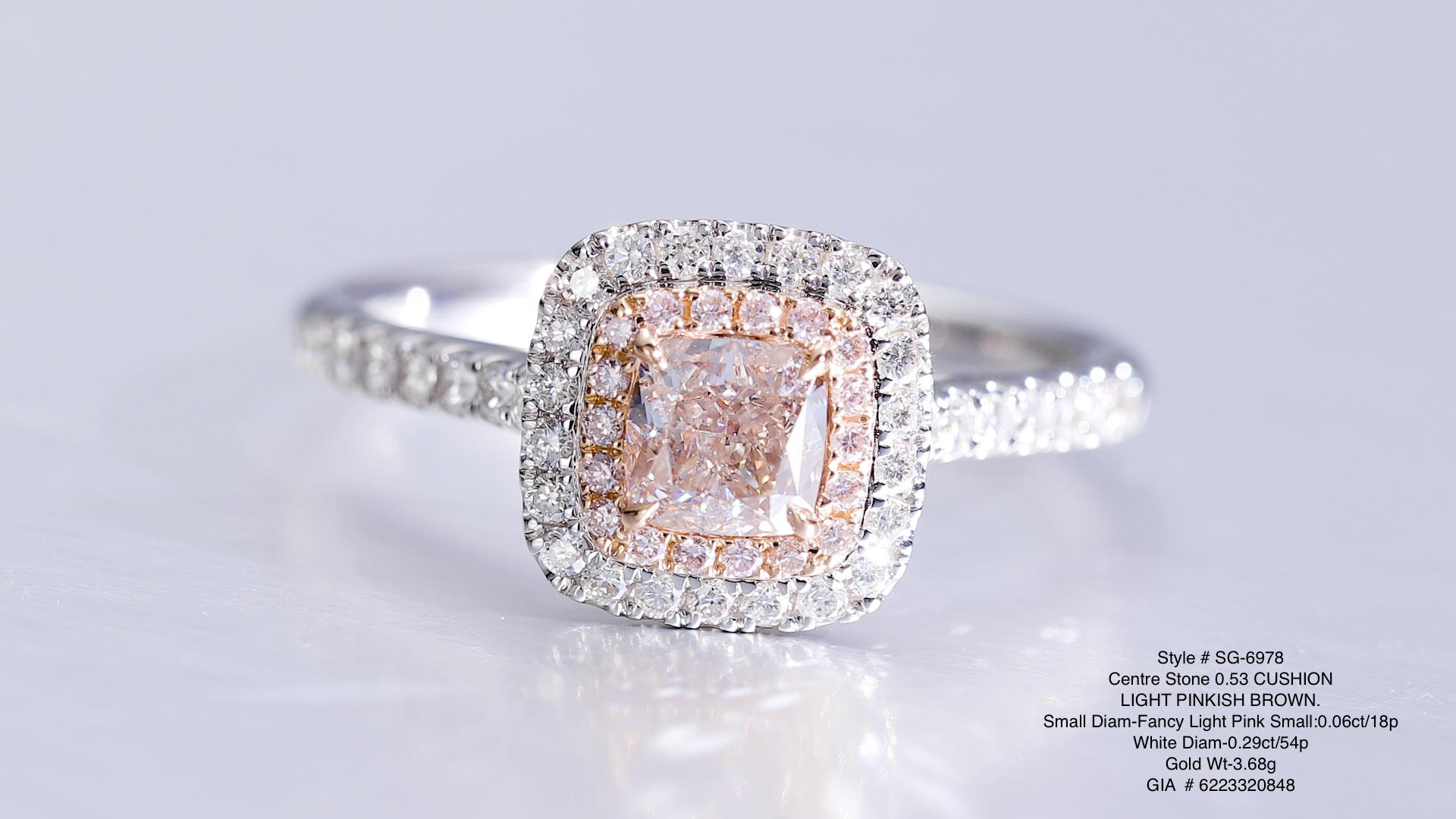 0.53ct Light Pinkish Brown Cushion cut natural diamond mounted on 18KT gold, with small round pink diamonds in halo and white diamond on the side.


This 0.53ct light pinkish brown solitaire ring, a true embodiment of elegance. The centerpiece