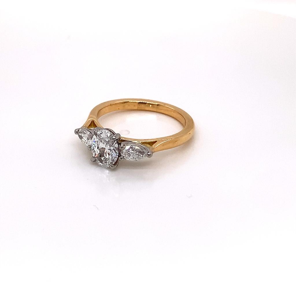 This remarkable ring features an oval GIA certified Diamond at its centre with a pear-shaped diamond on either side of it. The diamonds are held in a Platinum claw setting, and sit on an 18K Yellow Gold band.

The scintillating Diamond at the centre