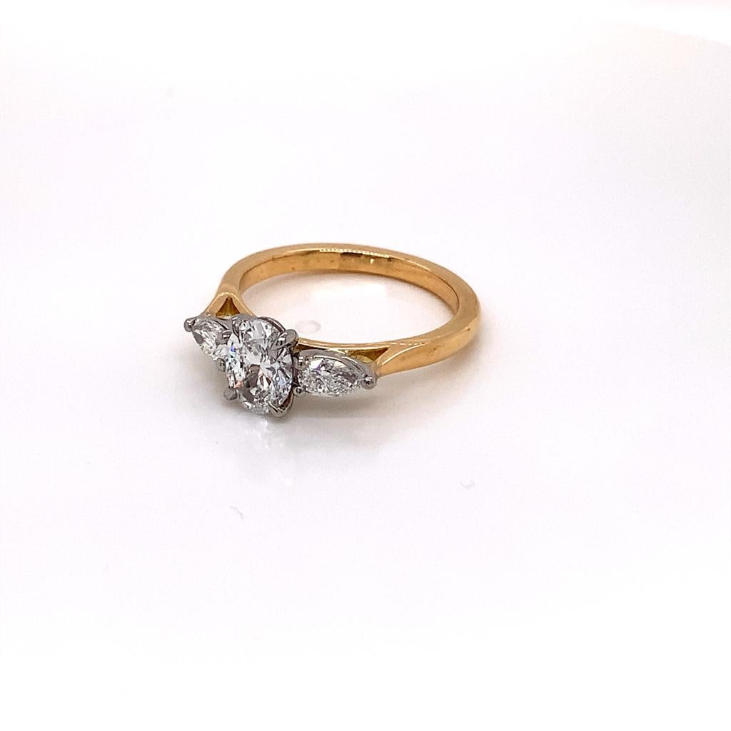 Cette bague remarquable est ornée d'un diamant ovale certifié par le GIA en son centre et d'un diamant en forme de poire de part et d'autre de celui-ci. Les diamants sont maintenus dans une monture à griffes en platine et reposent sur un bracelet en