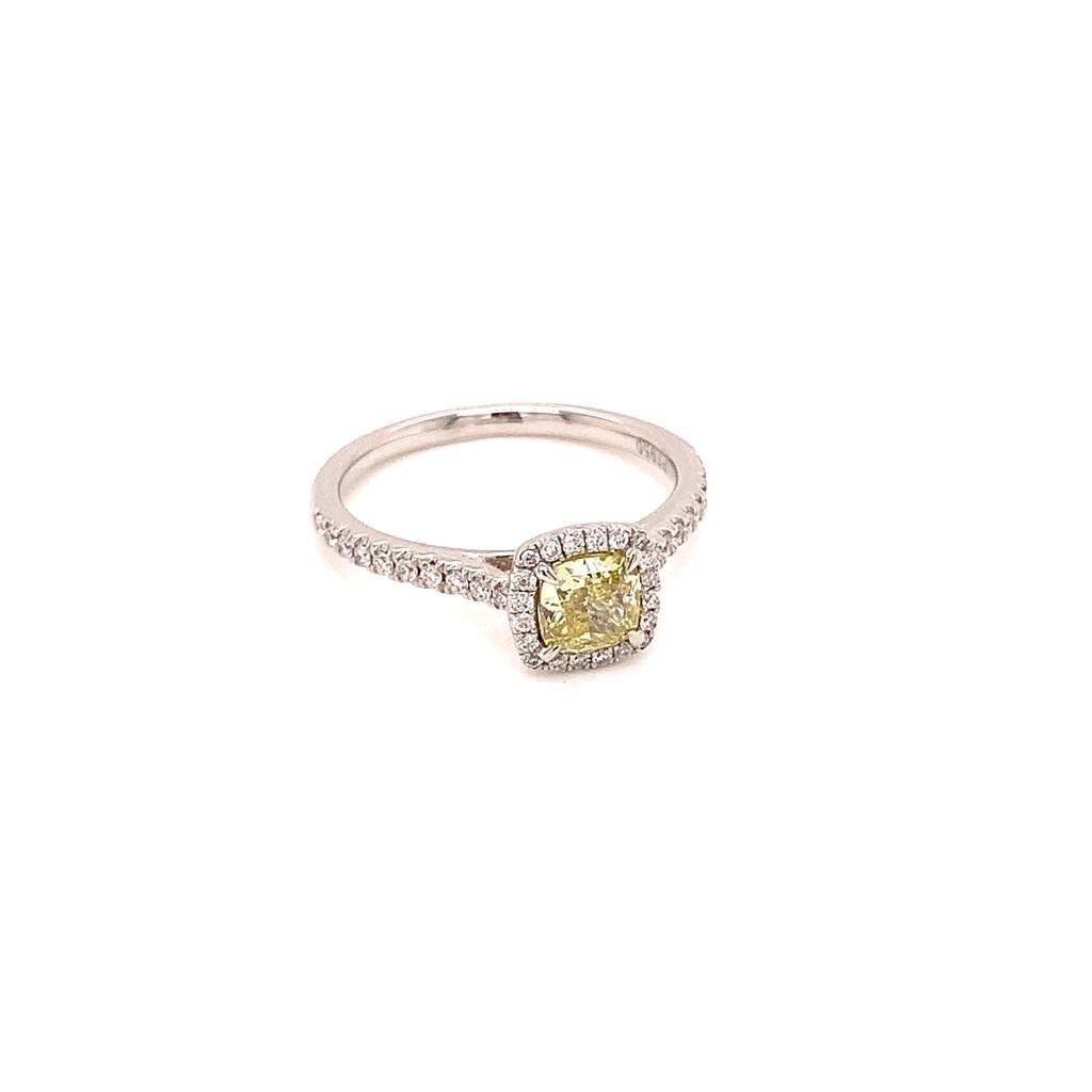 This Phenomenal Masterpiece features an exquisite 0.57 Carat Cushion Modified Brilliant Diamond of Natural Fancy Intense Yellow colour and SI1 clarity. It is surrounded by scintillating diamonds both around it and as shoulder diamonds, which are set