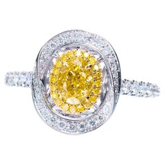 GIA Certified, 0.59 Natural Fancy Intense Yellow Oval Shaped Diamond Ring 18KT.