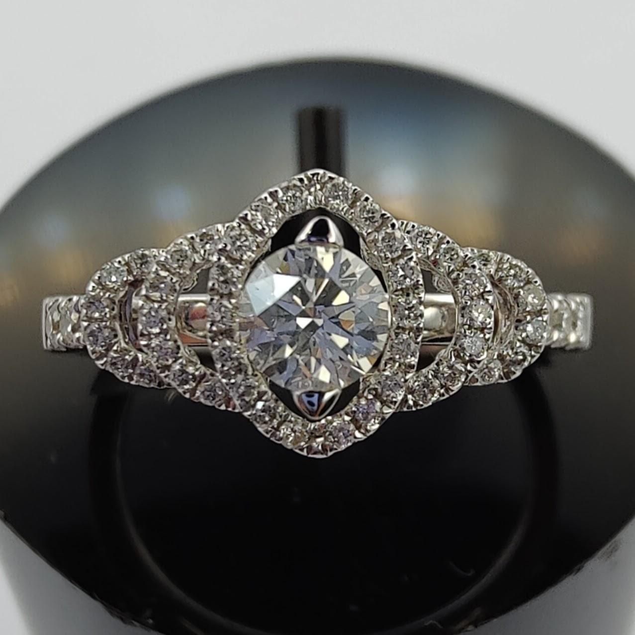 This stunning GIA certified diamond engagement ring is the perfect choice for your special day. The ring features a sparkling 0.61 carat round cut diamond set in a bridal cluster design, surrounded by three halos of smaller diamonds. The ring is