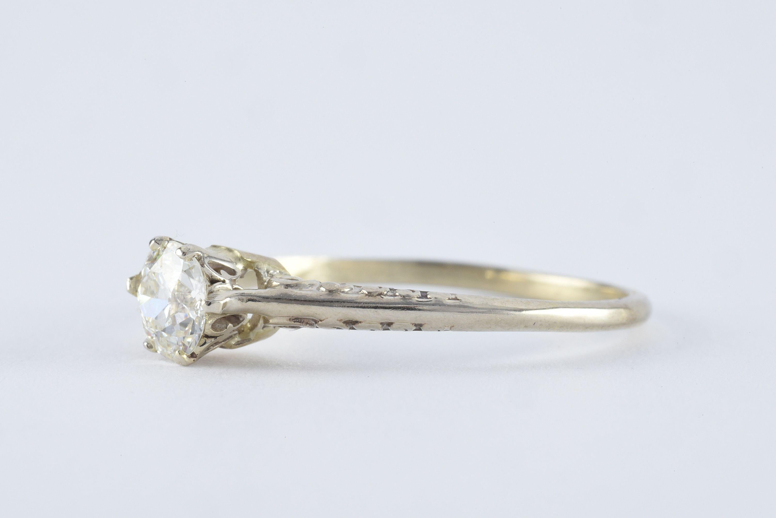 This vintage solitaire engagement band crafted in the 1930-40s is designed around a GIA-certified Old European cut diamond measuring 0.62 carats, J color, SI2 clarity fashioned from 10kt white gold with delicate swirling hand engraved details. 
