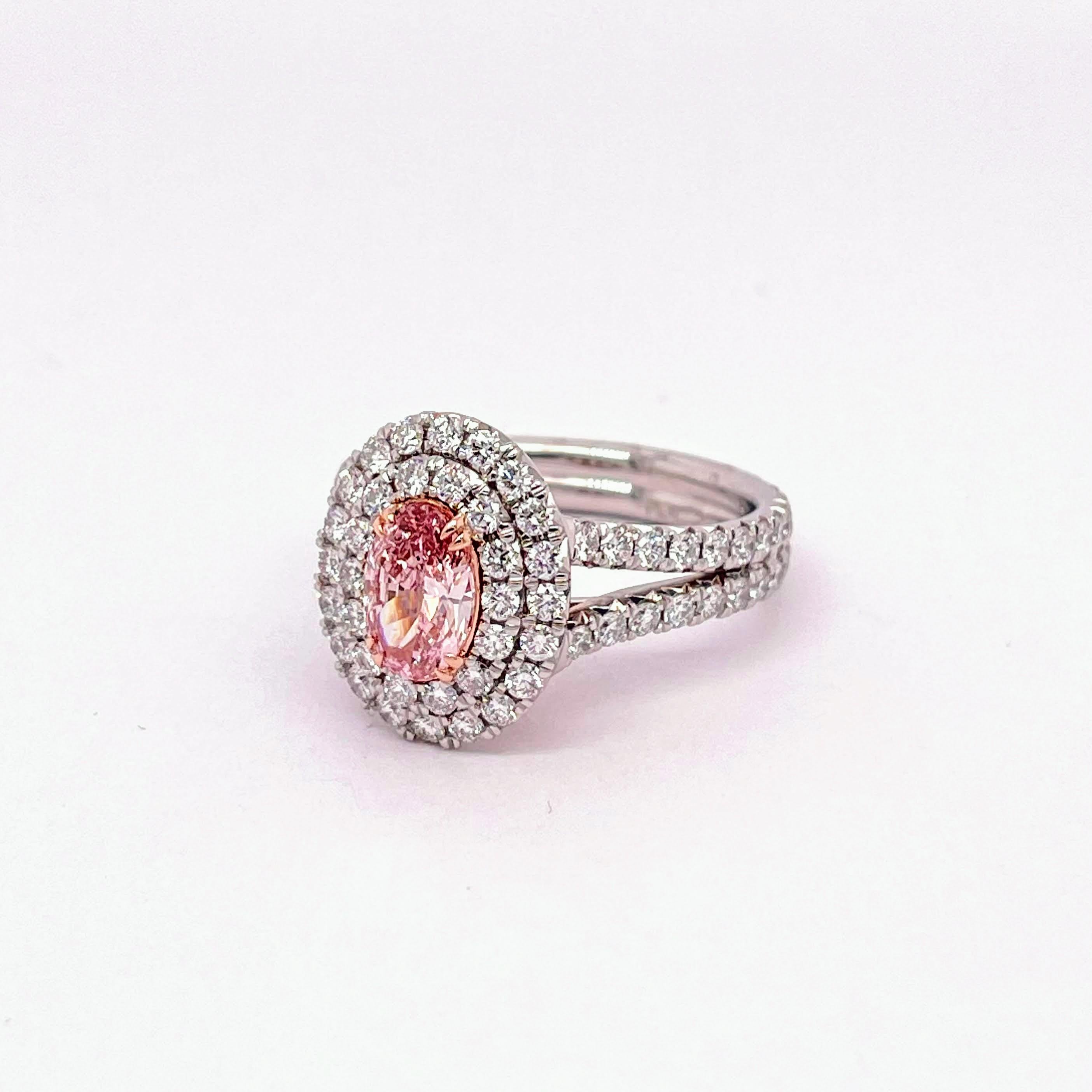 GIA Certified Oval Shape Cut Diamond 0.67, Fancy Intense Pink Color VS1 Clarity that rests on a 18K Rose basket and claw prongs. Platinum mounted double halo and split shank made of 1.44 carat of excellent colored round diamonds. Made to perfection