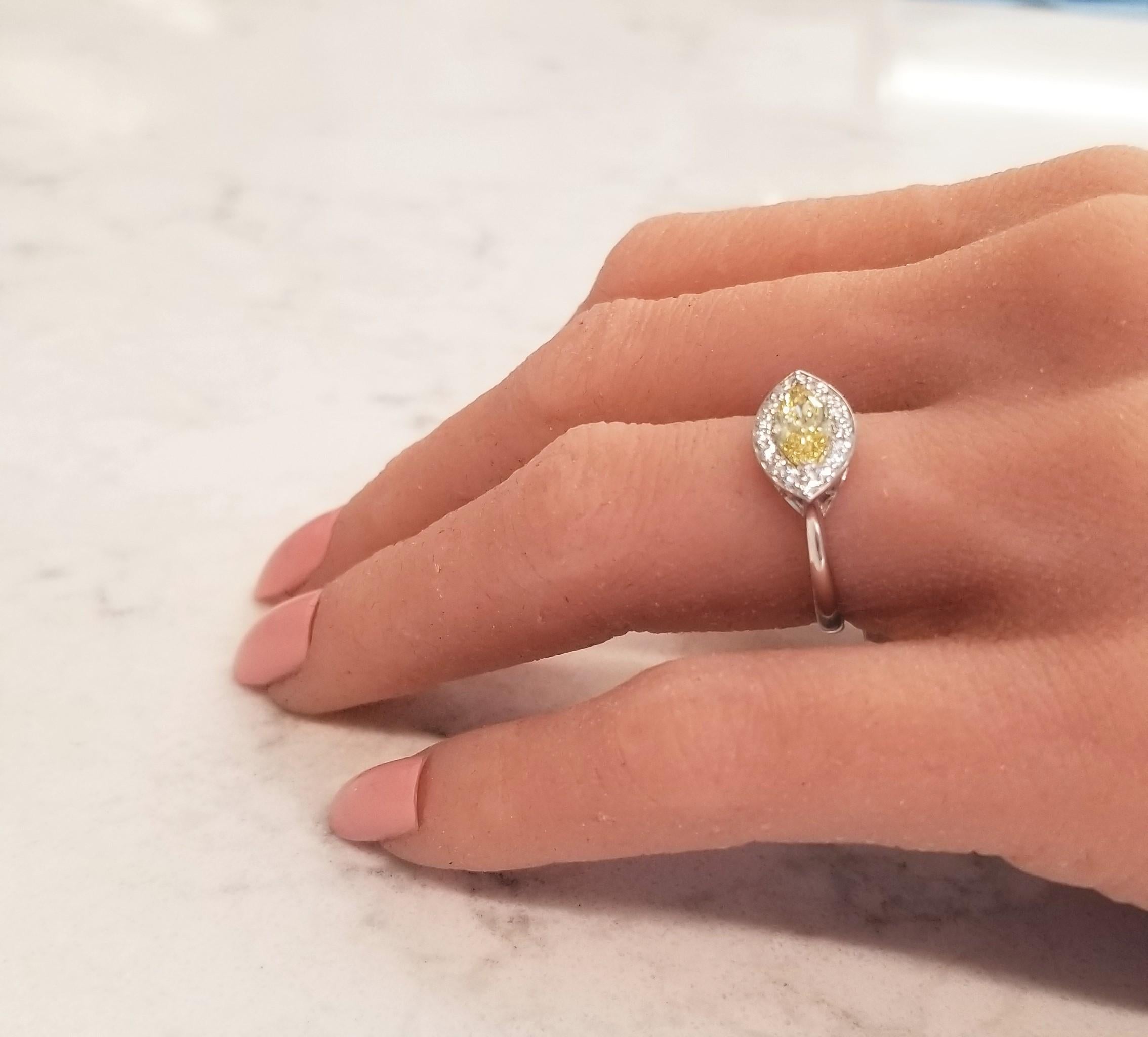 Dies ist ein Ring mit einem wunderschönen natürlichen, intensiv gelben Diamanten und einem außergewöhnlichen Design. Der Höhepunkt dieses Rings ist die Ost-West-Ausrichtung eines intensiv gelben Fancy-Diamanten. Mit einem Gewicht von 0,69 Karat,