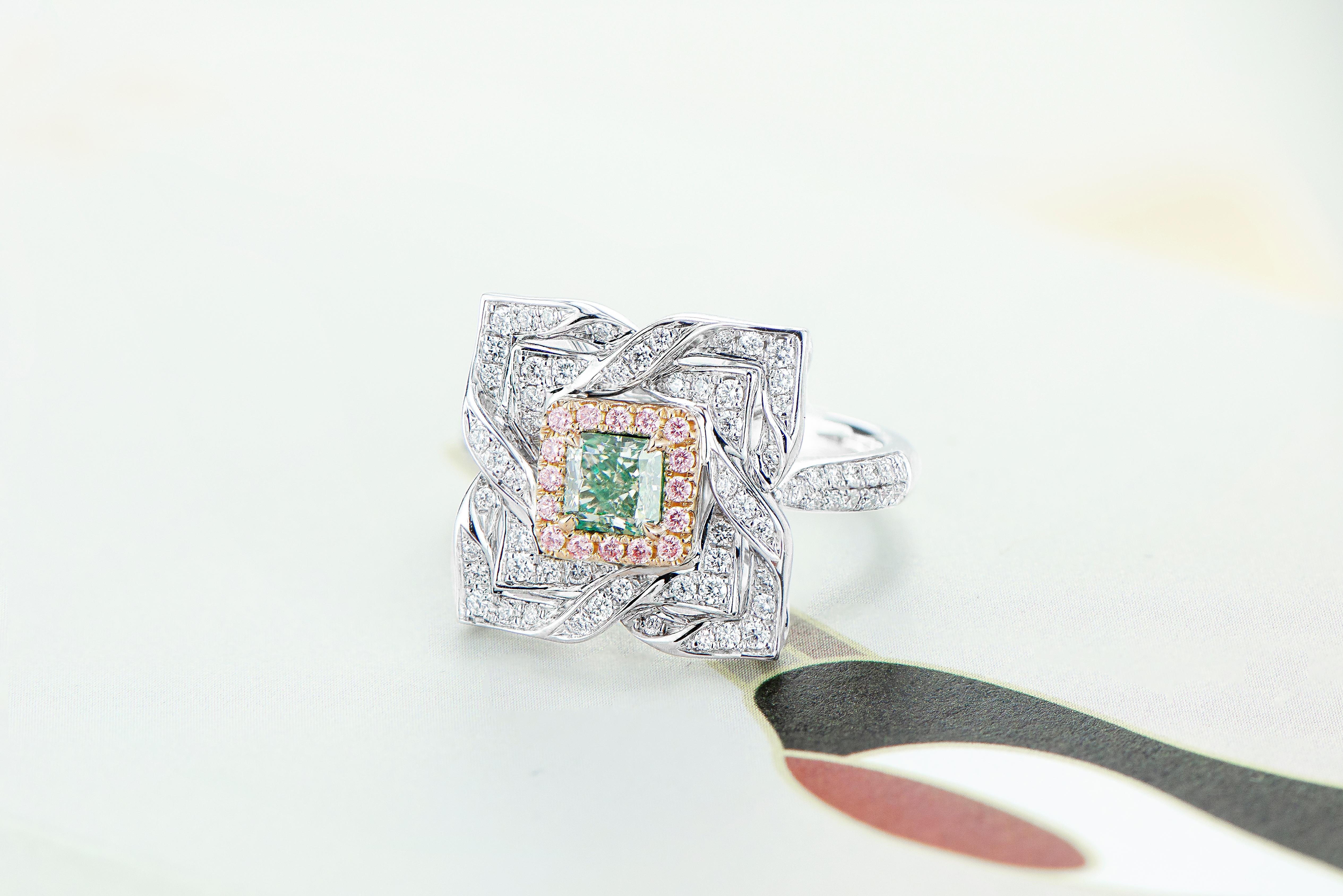  0.69ct Fancy Light Green Cushion Shape Natural Diamond, a true masterpiece of nature's beauty, elegantly set in 18kt gold. This captivating piece of jewelry is destined to be the centerpiece of your collection.

The lush green hue of the Fancy