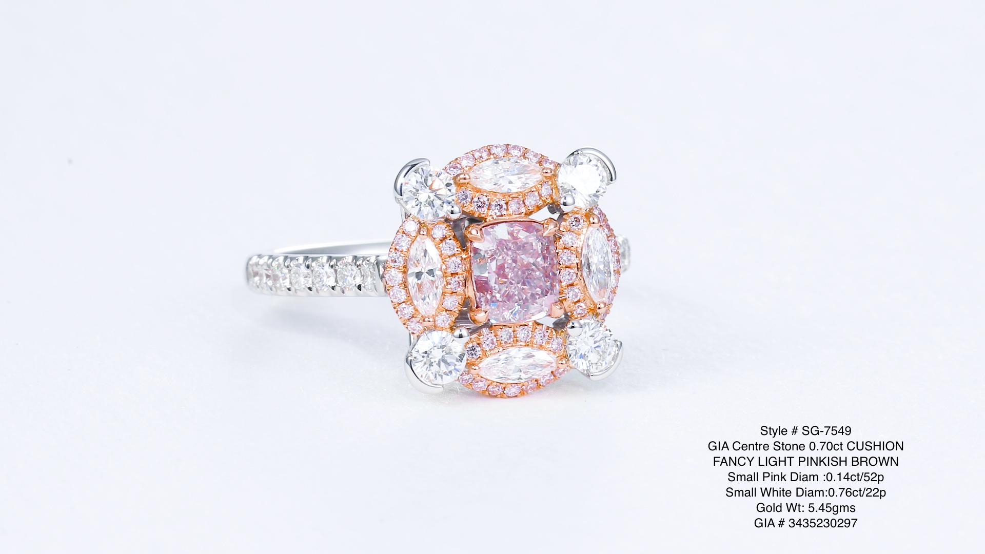 Ein bezaubernder Schatz: ein 0,70-karätiger, natürlicher, rosafarbener Diamant, zart gefasst in einem Ring aus 18-karätigem Gold. Mit bezaubernden weißen und rosafarbenen Diamanten geschmückt, strahlt dieses seltene Schmuckstück Eleganz und Charme