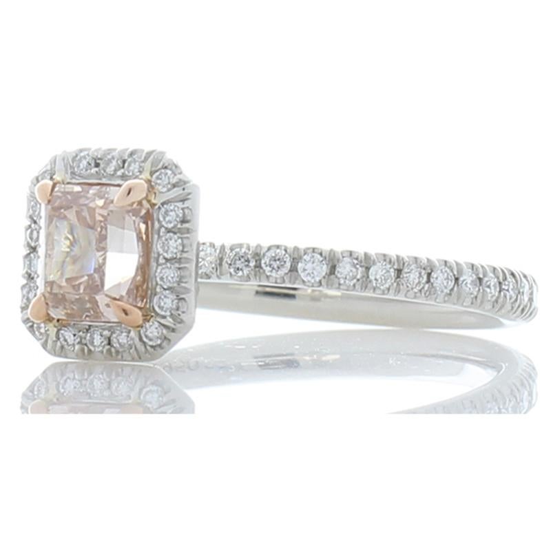 The design of this outstanding ring is ageless and graceful. It features an enchanting GIA certified 0.74 carat natural fancy pink-brown radiant cut diamond center. The diamond is from Australia. Its attractiveness is enhanced by a sparkling halo of