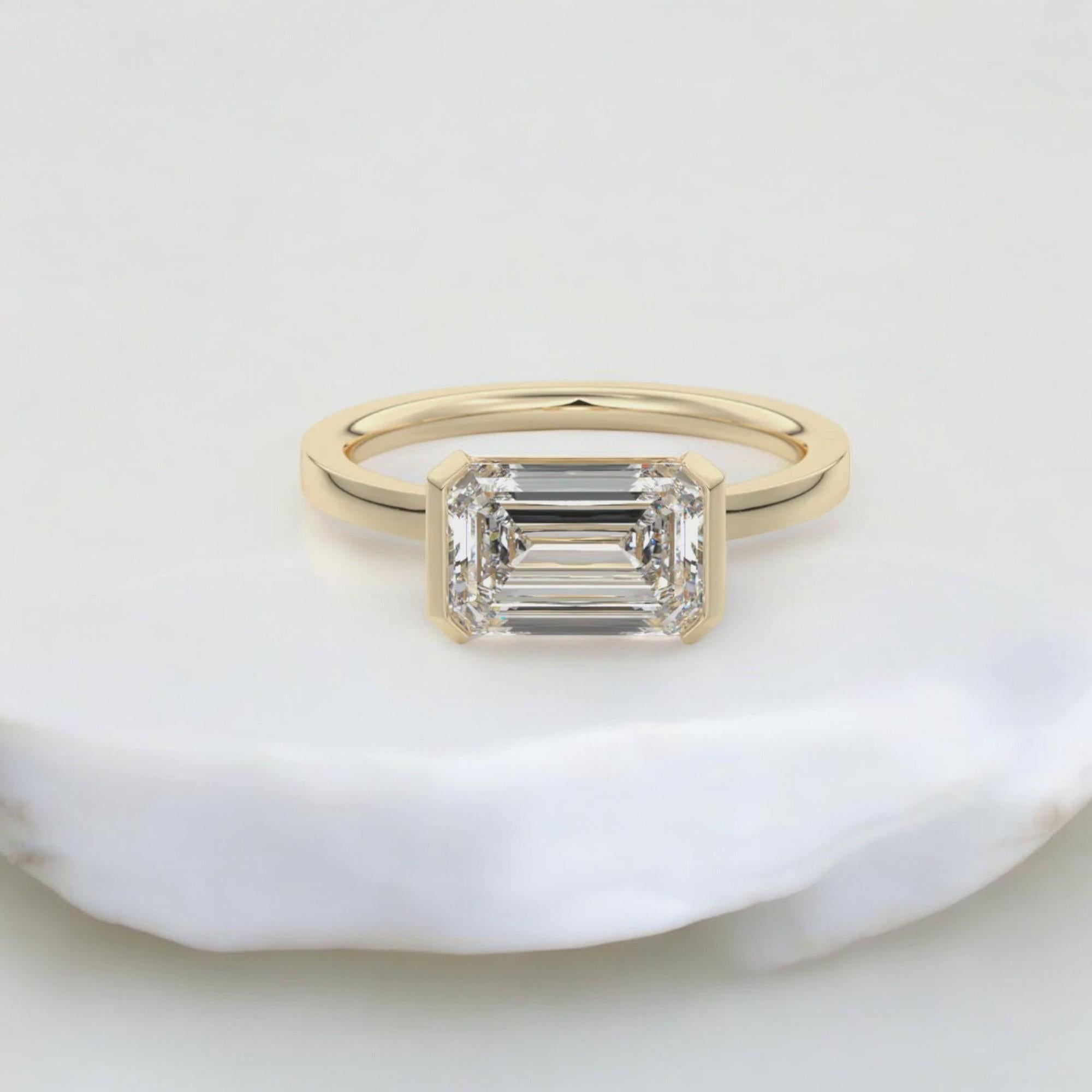 Dieser atemberaubende Ring mit einem Gewicht von 0,75 Karat ist mit einem wunderschönen Diamanten im Smaragdschliff in einer Solitärfassung mit halber Lünette besetzt. Der Diamant ist GIA-zertifiziert und hat einen sehr leicht eingeschlossenen
