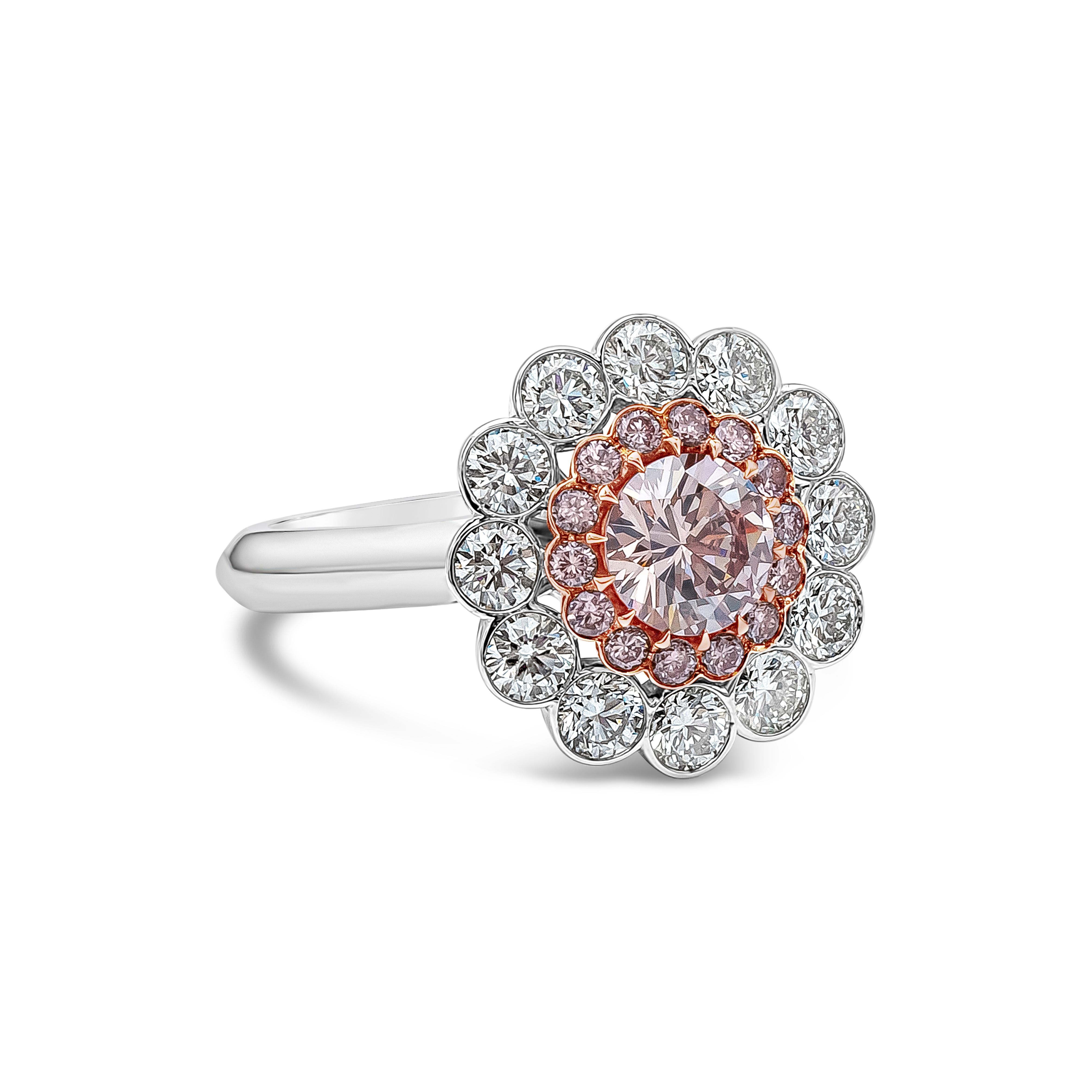 Rare and stylish piece of high end jewelry showcasing a vibrant 0.77 carat brilliant round pink diamond certified by GIA as natural fancy pink, SI1 clarity. Set in a fourteen prong 18k rose gold basket surrounded by row of 14 pink round diamonds on