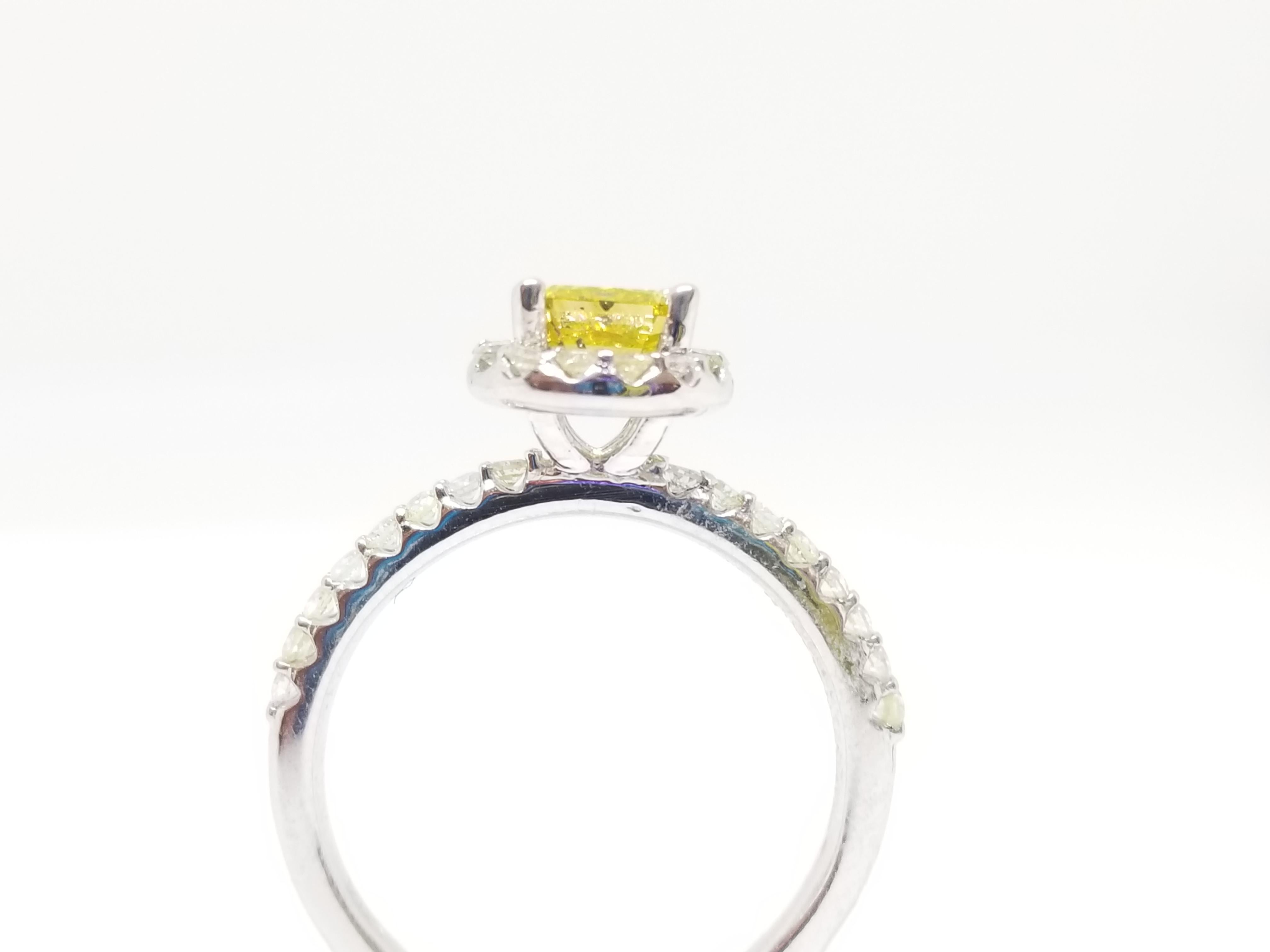 Fancy vivid yellow radiant cut natural diamond weighing 0.78 carats by GIA. surrounded by paved white diamonds in the halo setting. Its transparency and luster are excellent. set on 14K white gold, this pear ring is the ultimate gift for