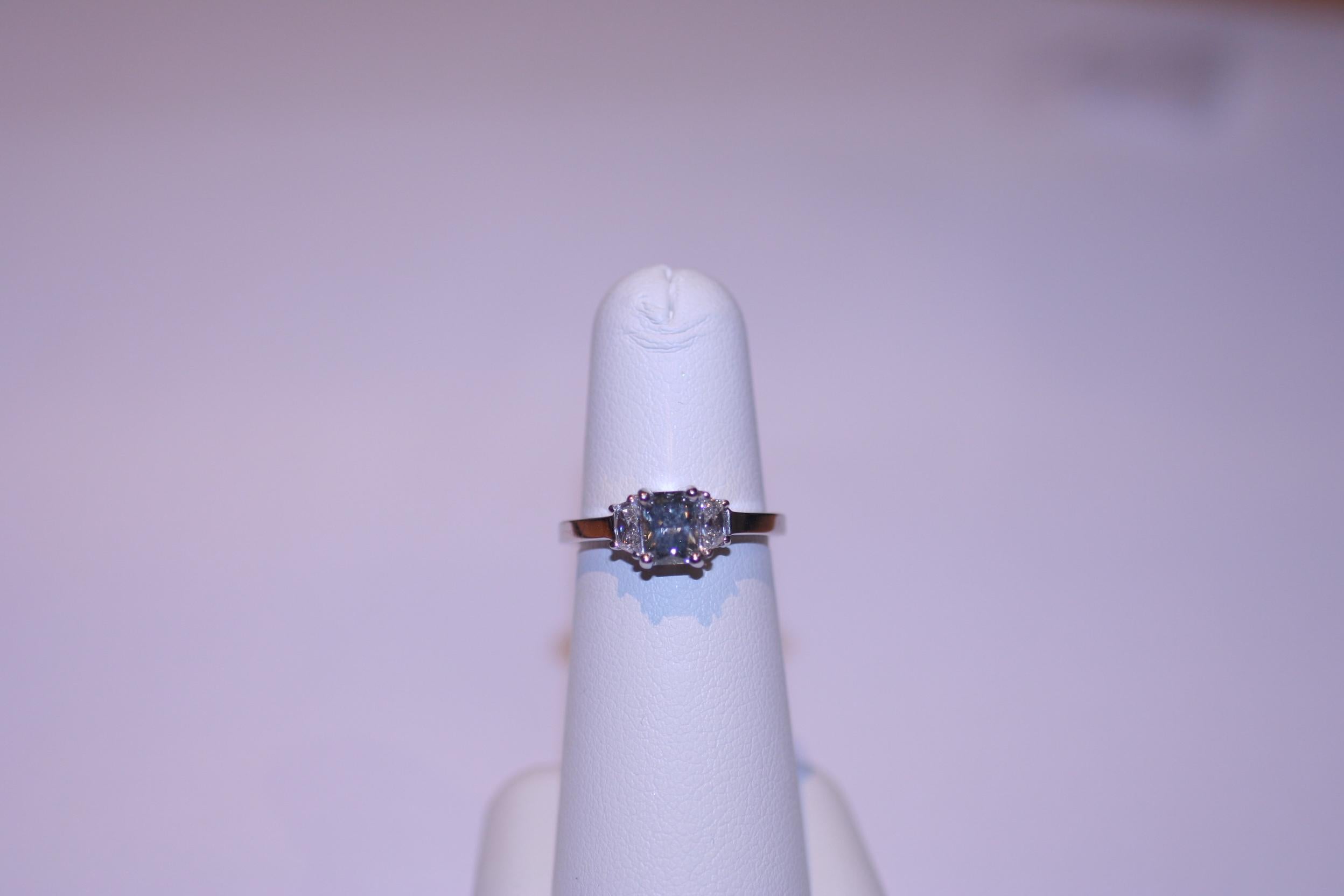 Custom Handmade 18K White Gold Ring set with GIA certified Fancy Blue Gray Diamond weighing 0.81 carat, and 2 Trapezoids Cut diamonds, F color VS clarity, weighing 0.40 carats.

GIA# 15807745