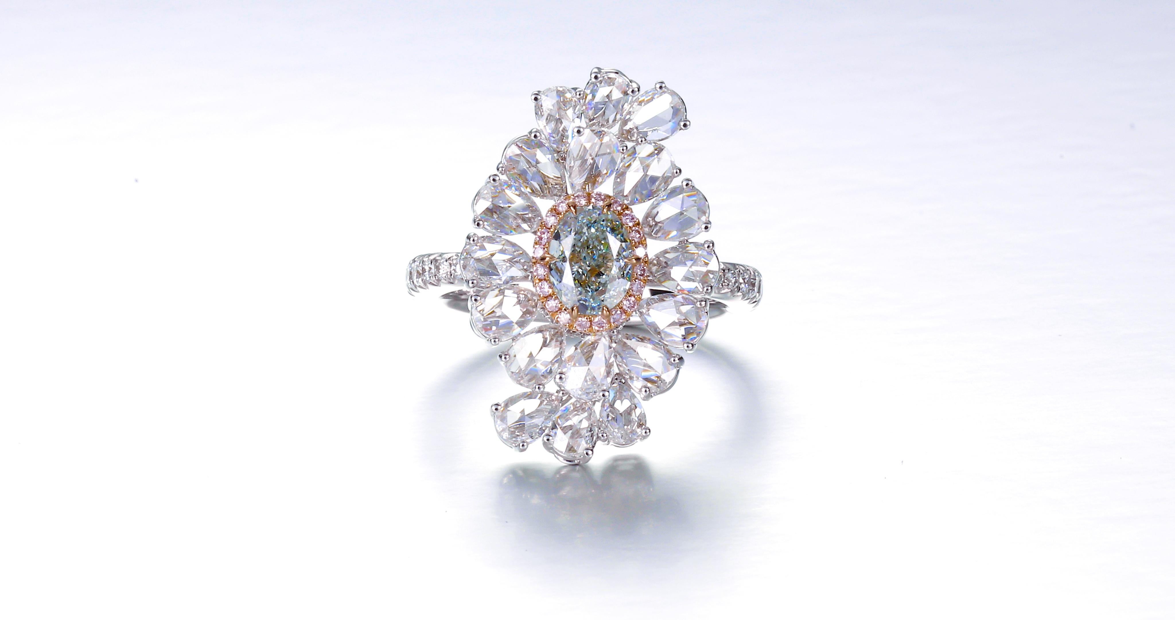 Wir präsentieren ein wahrhaft bezauberndes und hypnotisierendes Schmuckstück mit einem bemerkenswerten Herzstück - einem GIA-zertifizierten 0,83-karätigen natürlichen ovalen Fancy-Diamanten von blau-grüner Farbe. Dieser exquisite Edelstein steht im