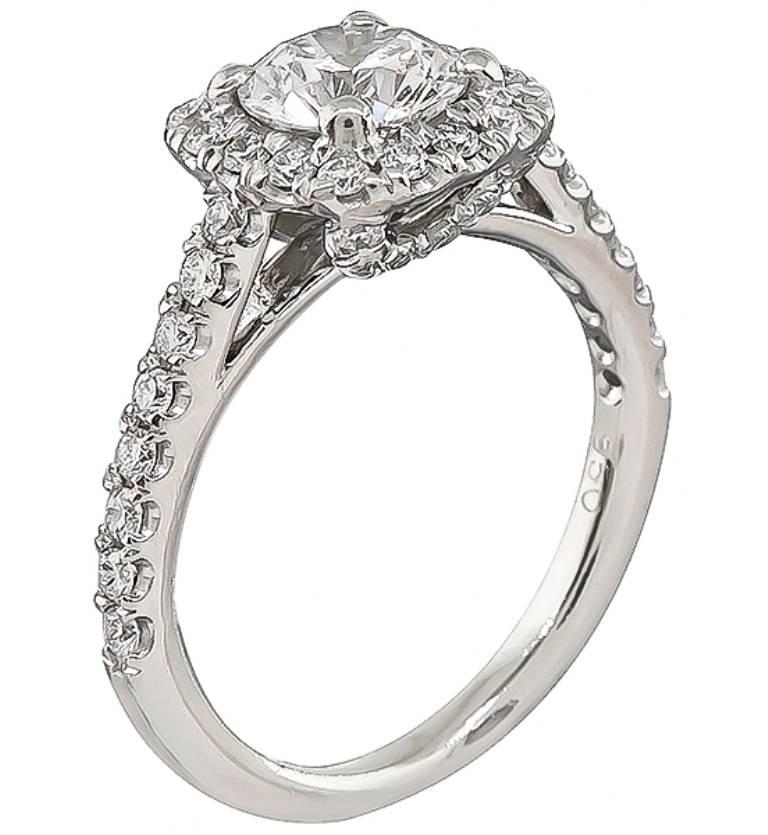 This enticing platinum engagement ring is centered with a sparkling GIA certified round brilliant cut diamond that weighs 0.90ct. graded E color with SI2 clarity. The center diamond is accentuated by dazzling round cut diamonds that weigh