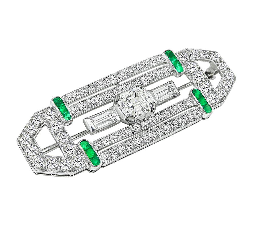 This is a gorgeous platinum pin. The pin is centered with sparkling GIA certified emerald cut diamond that weighs 0.98ct. The color of the diamond is F with VS1 clarity. The center diamond is accentuated by dazzling baguette and round cut diamonds