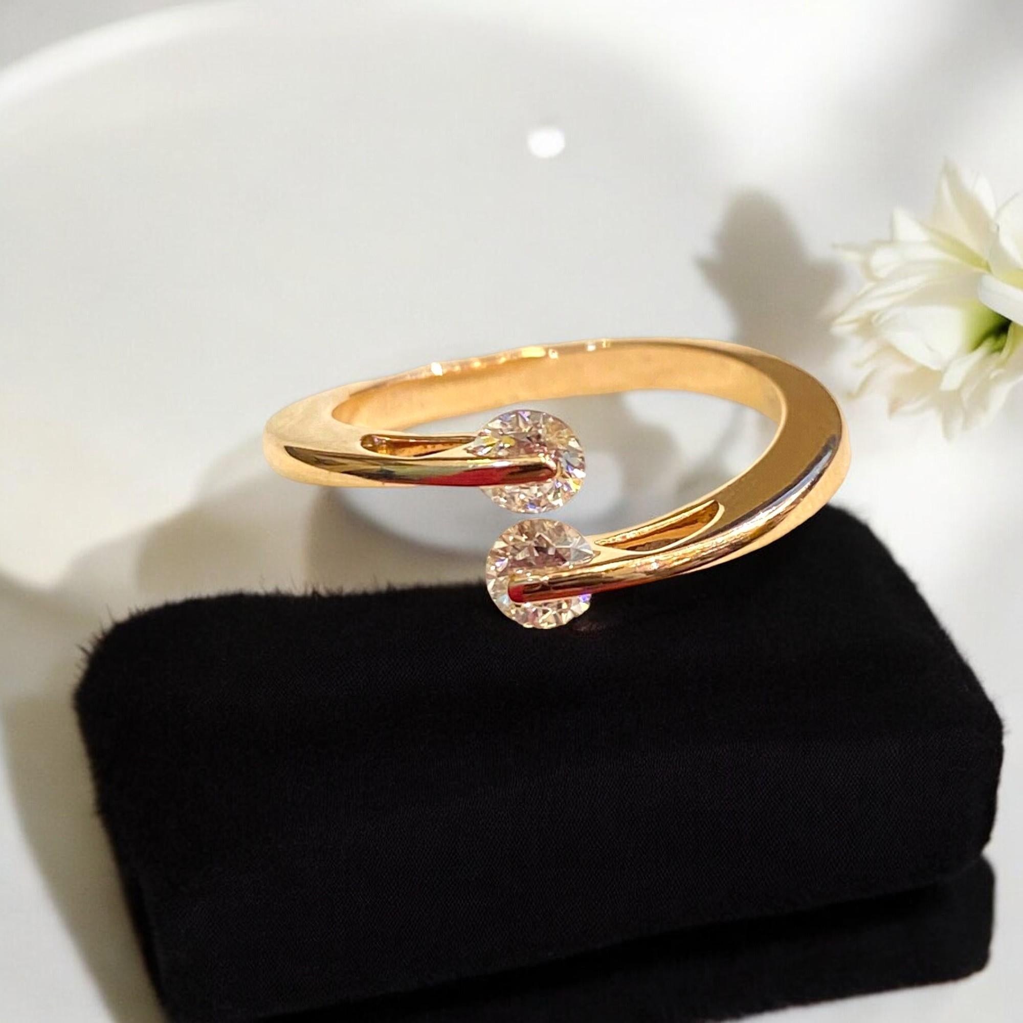 Questo elegante anello di fidanzamento presenta uno splendido diamante rotondo con taglio a brillante in un'incastonatura solitaria, accentuata da due diamanti più piccoli. Realizzato in oro rosa 18 carati, ha un peso totale di 0,50 carati ed è