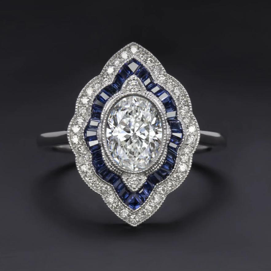 Captivating Art Deco Inspired 1 Carat Oval Diamond and Sapphire Ring in 14k White Gold

Dive into the elegance of the Art Deco era with this stunning diamond and sapphire ring, featuring a brilliant 1 carat oval cut diamond at its center. This GIA