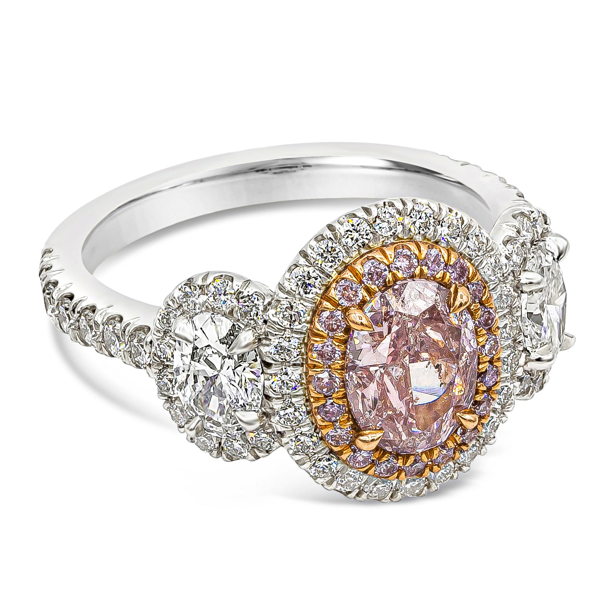 Well crafted engagement ring showcasing a 1.00 carat pink diamond certified by GIA as Fancy Intense Pink color, set in a double-halo mounting set with brilliant round 0.12 carat total pink and 0.58 carat total white diamonds. Flanked by two oval cut