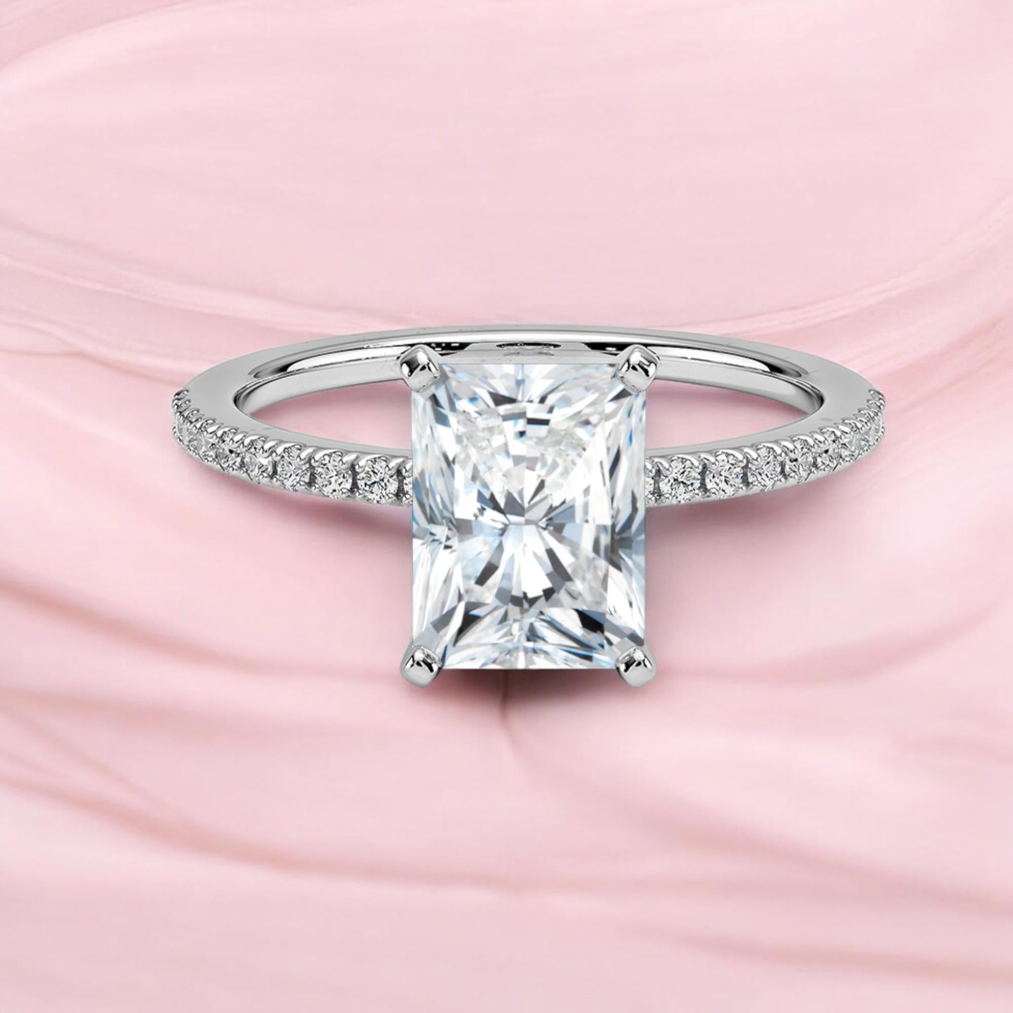 Questo splendido anello di fidanzamento presenta un diamante radioso e rotondo con un peso totale di 1 carato, incastonato in un solitario in oro bianco 18 carati con accenti. Il diamante è certificato GIA e ha un grado di purezza di Very Slightly