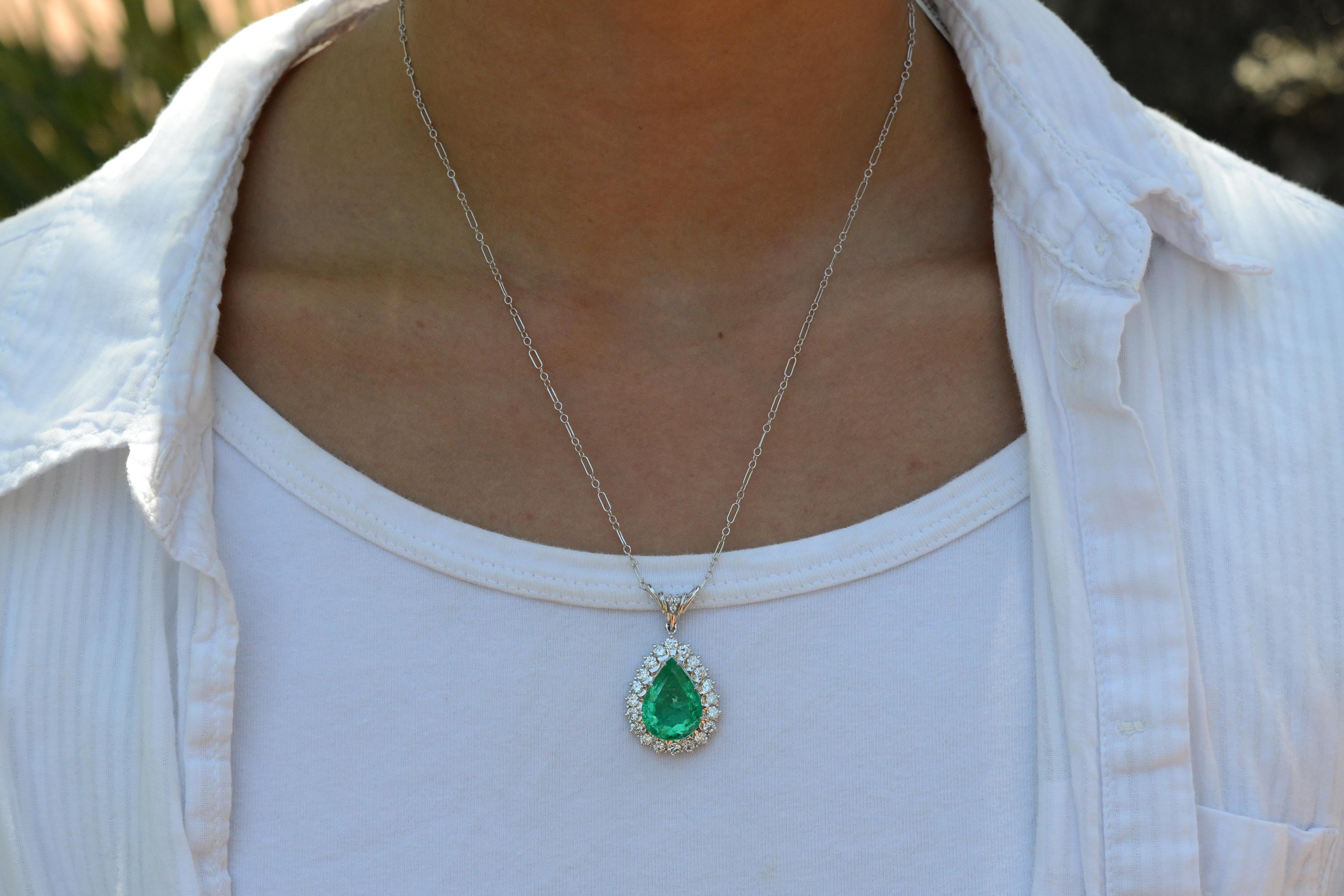 Adorn yourself in fantastic grandeur with this exquisite estate 10.38 carat emerald pendant. Crafted with a GIA certified Colombian emerald, the gemstone is perfectly cut and faceted into a perfect pear to maximize radiance. Accented by 23 dazzling