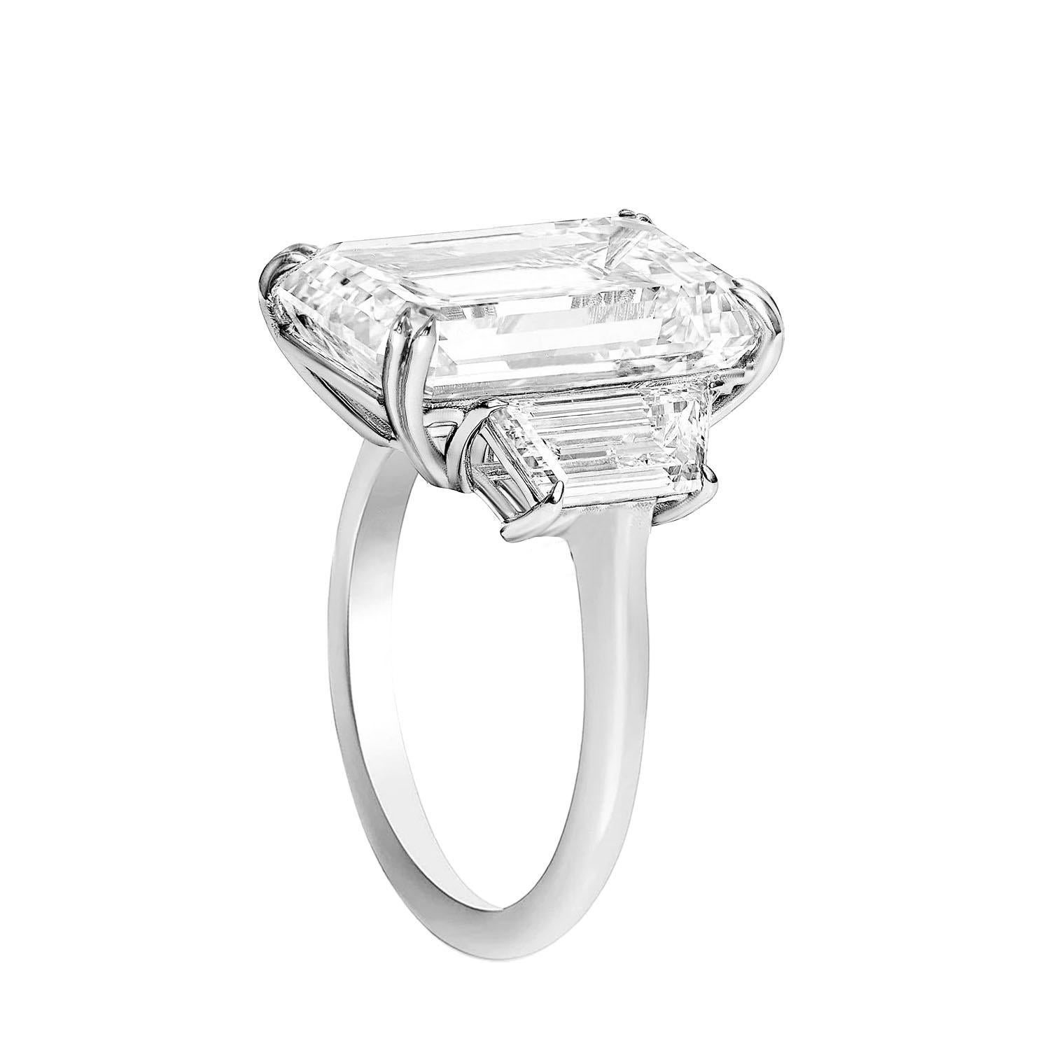 exquisite piece of jewelry! The emerald cut diamond weighing 10 carats with F color and VVS1 clarity would undoubtedly be dazzling on its own, but paired with trapezoid-shaped diamonds totaling 1 carat each, it adds even more elegance and